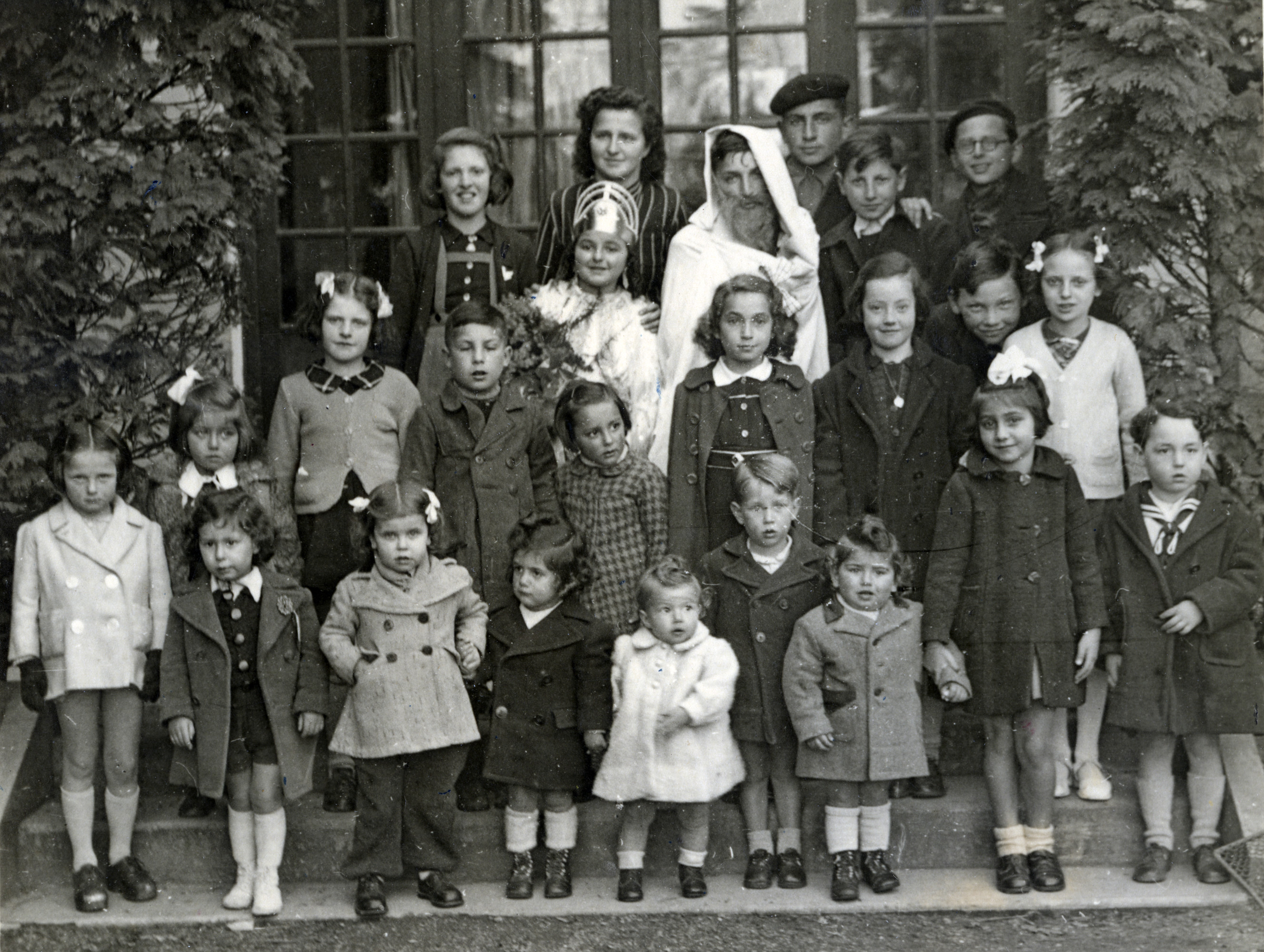 Jewish children celebrate Purim, probably shortly after the war.

Claire is in the second row from the back, on the far left, wearing a crown and dressed as Queen Esther.