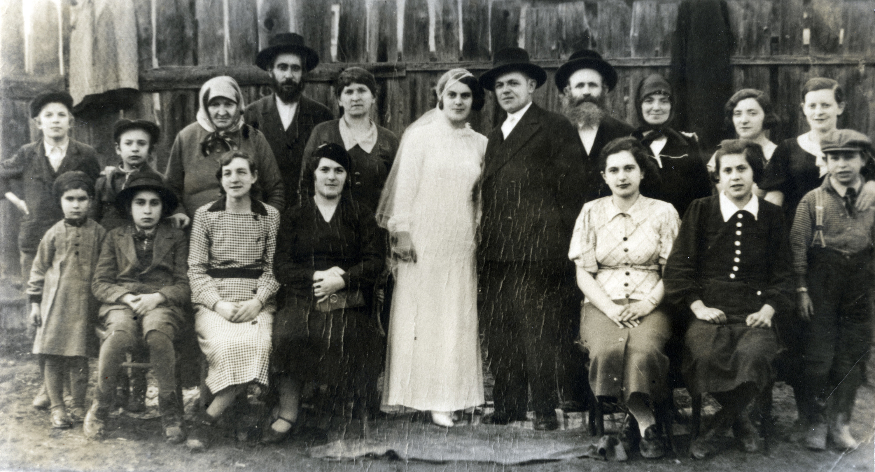 Group photograph of  wedding attendees in Solotvino, Czechslovakia.

Among those pictured are Israel Menachem Perl  and his wife Rachel Golda Perl (back row, fourth and fifth from the left), and their children Nahum (back row, far left), Chana (front row, far left), David (front row, second from the left), Rivka (front row, second from the right), and Alexander, (front row, far right).  The names of the bride and groom are not known.