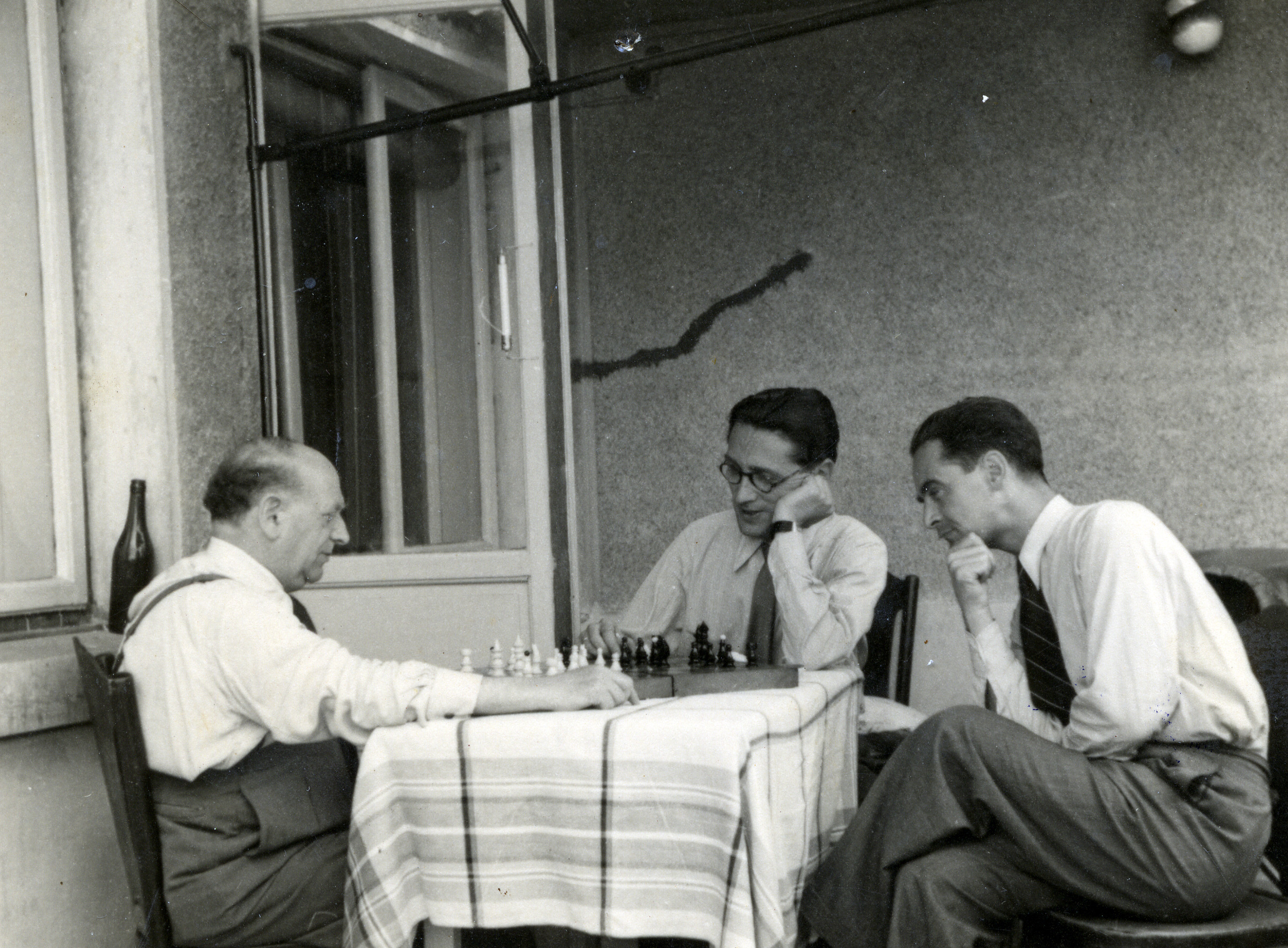 Eliezer Josef (left) plays chess with his son-in-law, Felix Gelehter, as Jean Greceanu looks on.