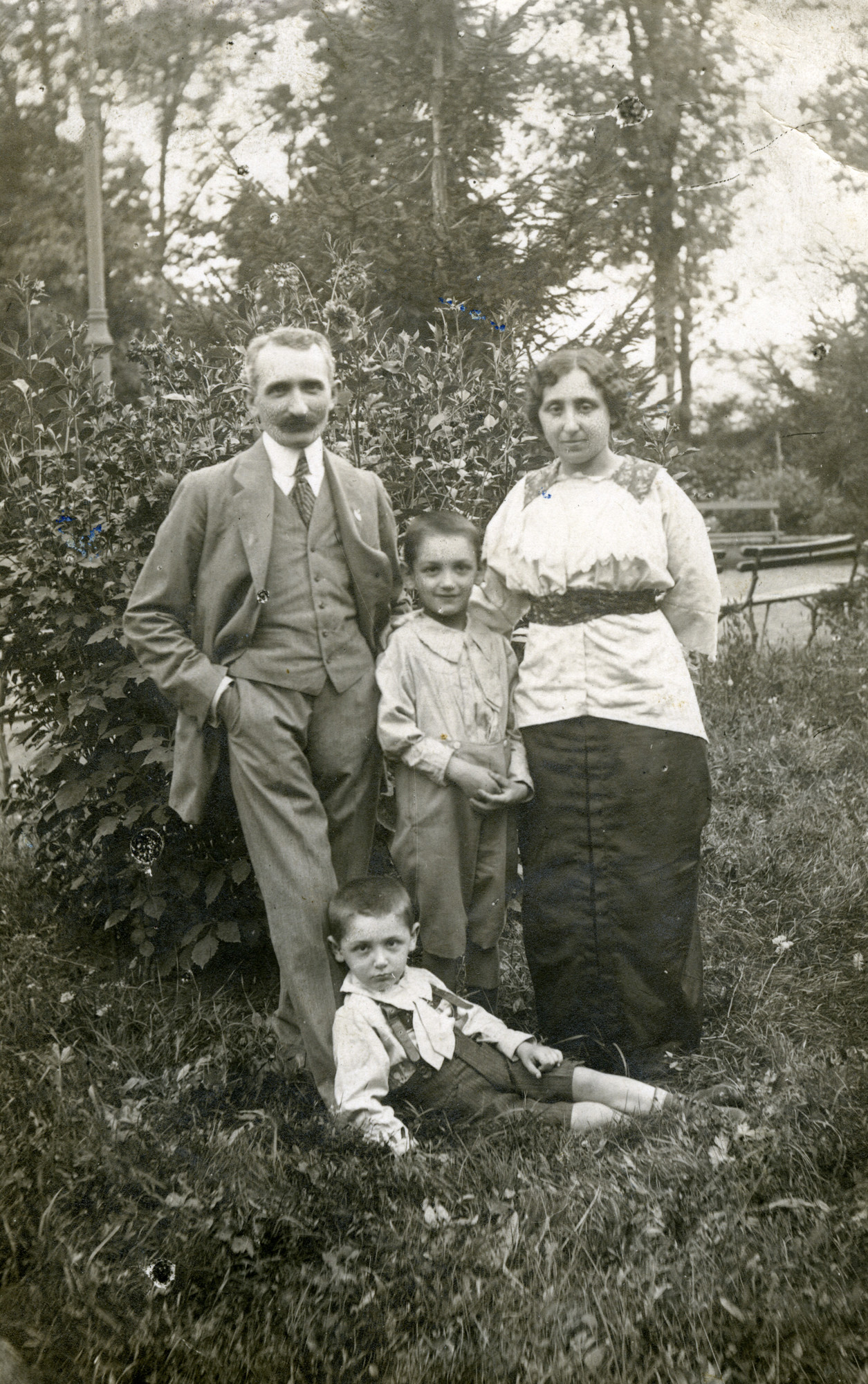 Outdoor portrait of a Romanian Jewish family.

Pictured are  Milo and Helene Gelehrter with their sons, Felix (lower) and Moni.