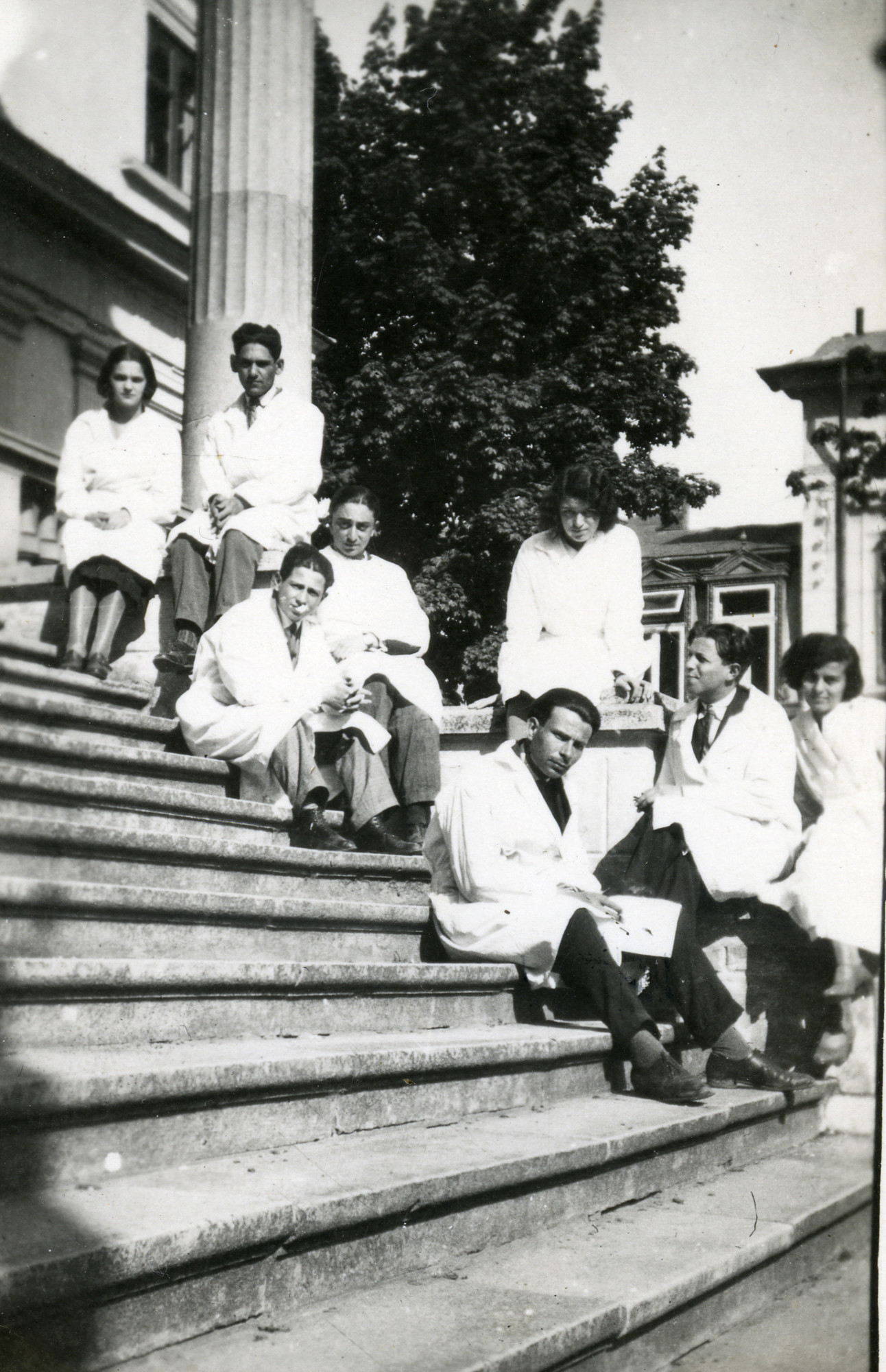 A Jewish Romanian woman poses on an outdoor stairwell with her medical school classmates. 

Among those pictured is Charlotte Josef (far left).