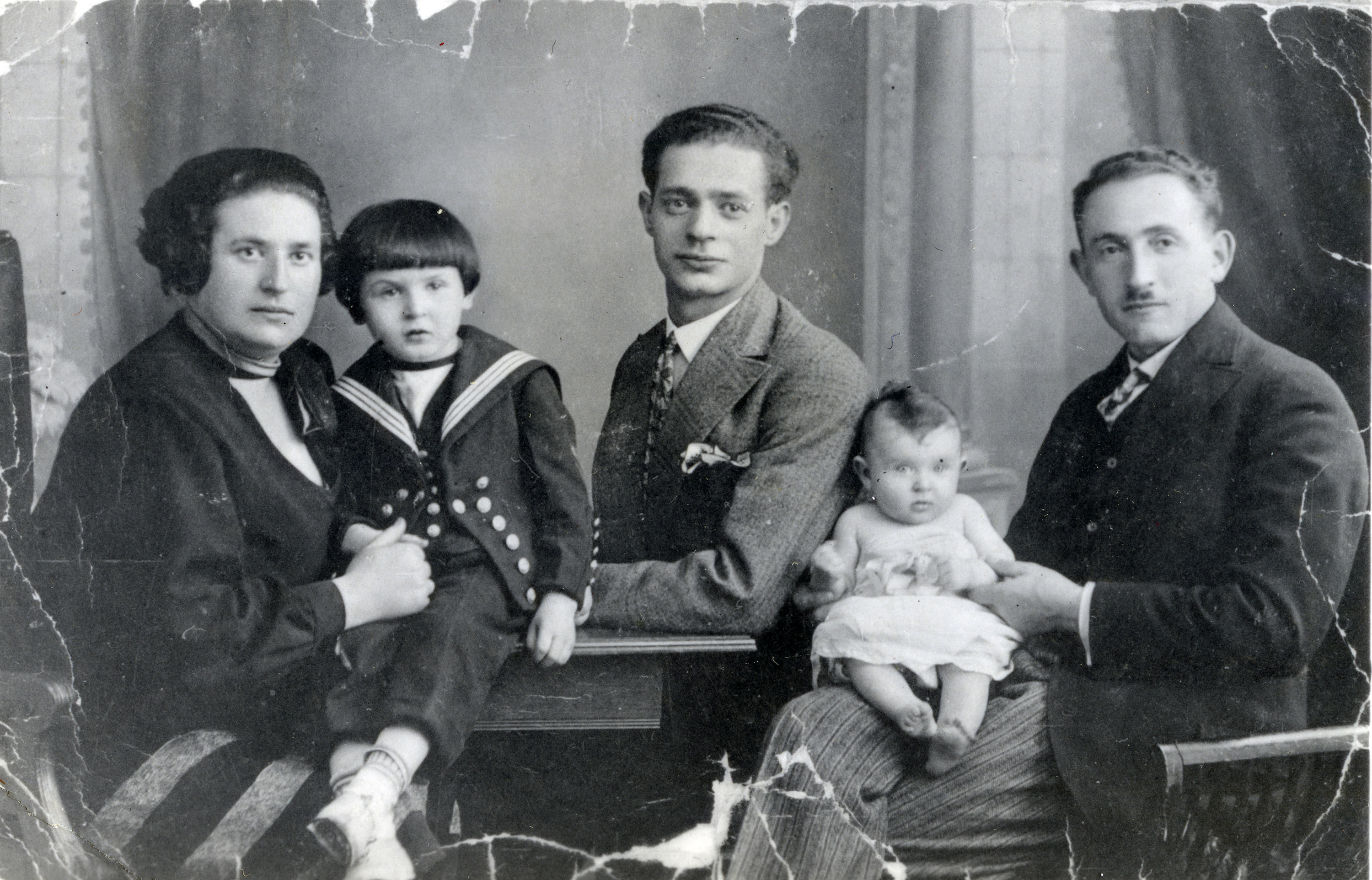 Studio portrait of a German Jewish family.

Pictured are Tehilla and David Fachler with their children Eli and Miriam, and David's brother Theo Fachler (center).