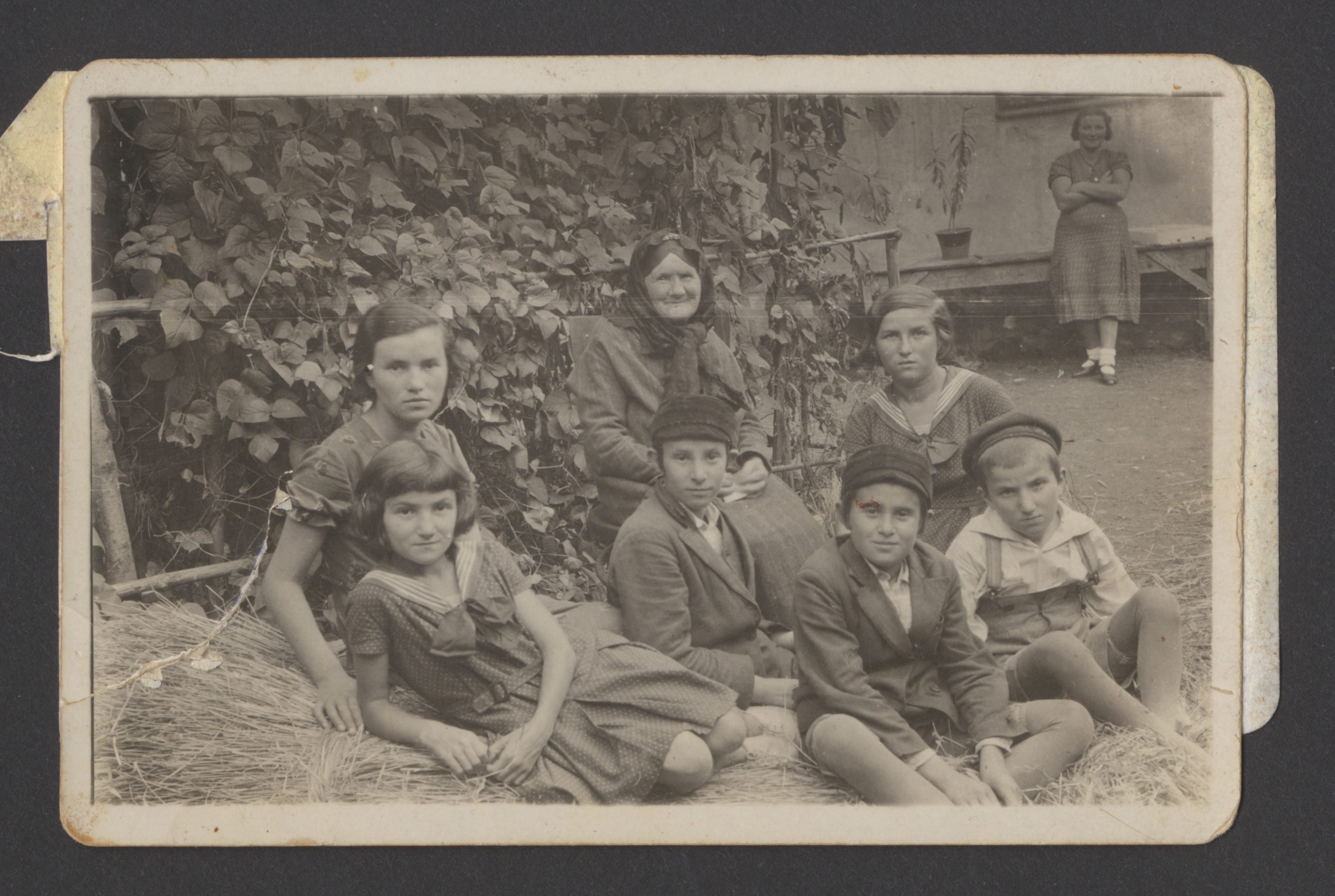 A Polish Jewish family gathers for a photograph in the backyard of their home in Nowy Sacz.

Pictured is Miriam Ullman (back, center) with her grandchildren:  siblings Blima (far left), Moishe (center), and Mayer Spiro (front, second from the right); and siblings Sally and Deborah (wearing sailor dresses), and Yoel Ullman (far right).