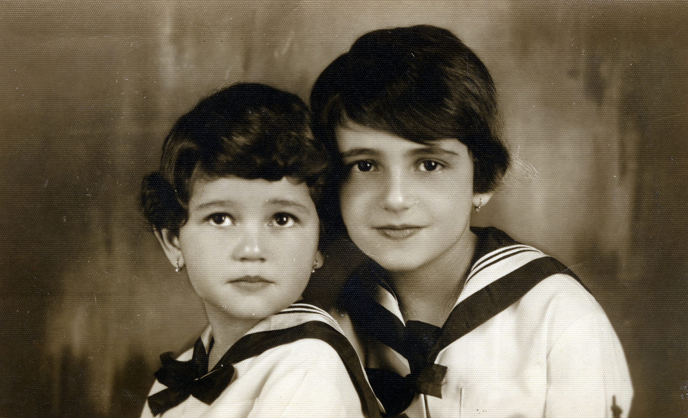 Studio portrait of Hungarian Jewish sisters.

Pictured are Susan (Suzsi) and Georgina (Gyorgyi) Fehrer.