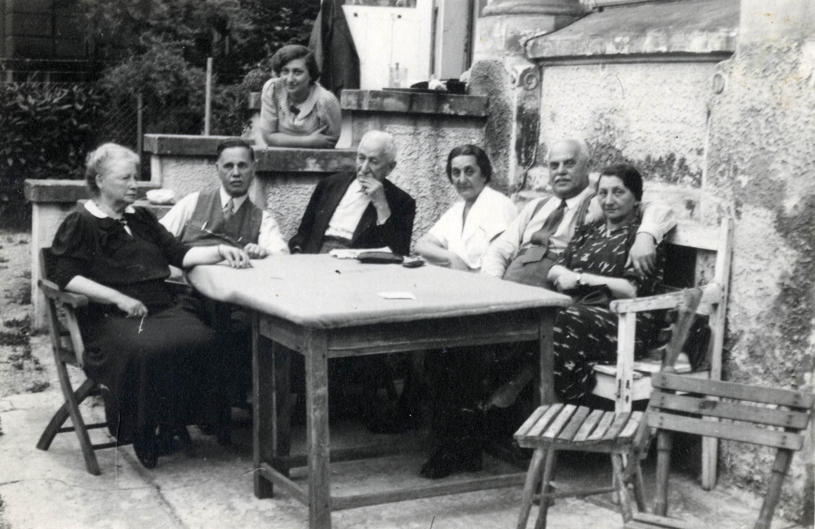 Friends and family gather around an outdoor table, on a terrace in Vienna.

Among those pictured are Philip and Sidonie Suss (far right).
