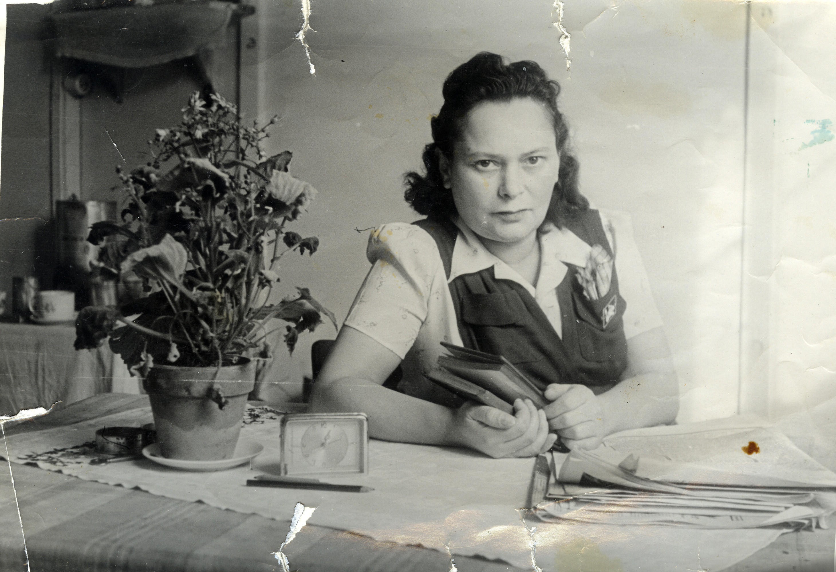 Guta Graubart seated at a table in the Pocking displaced persons camp.