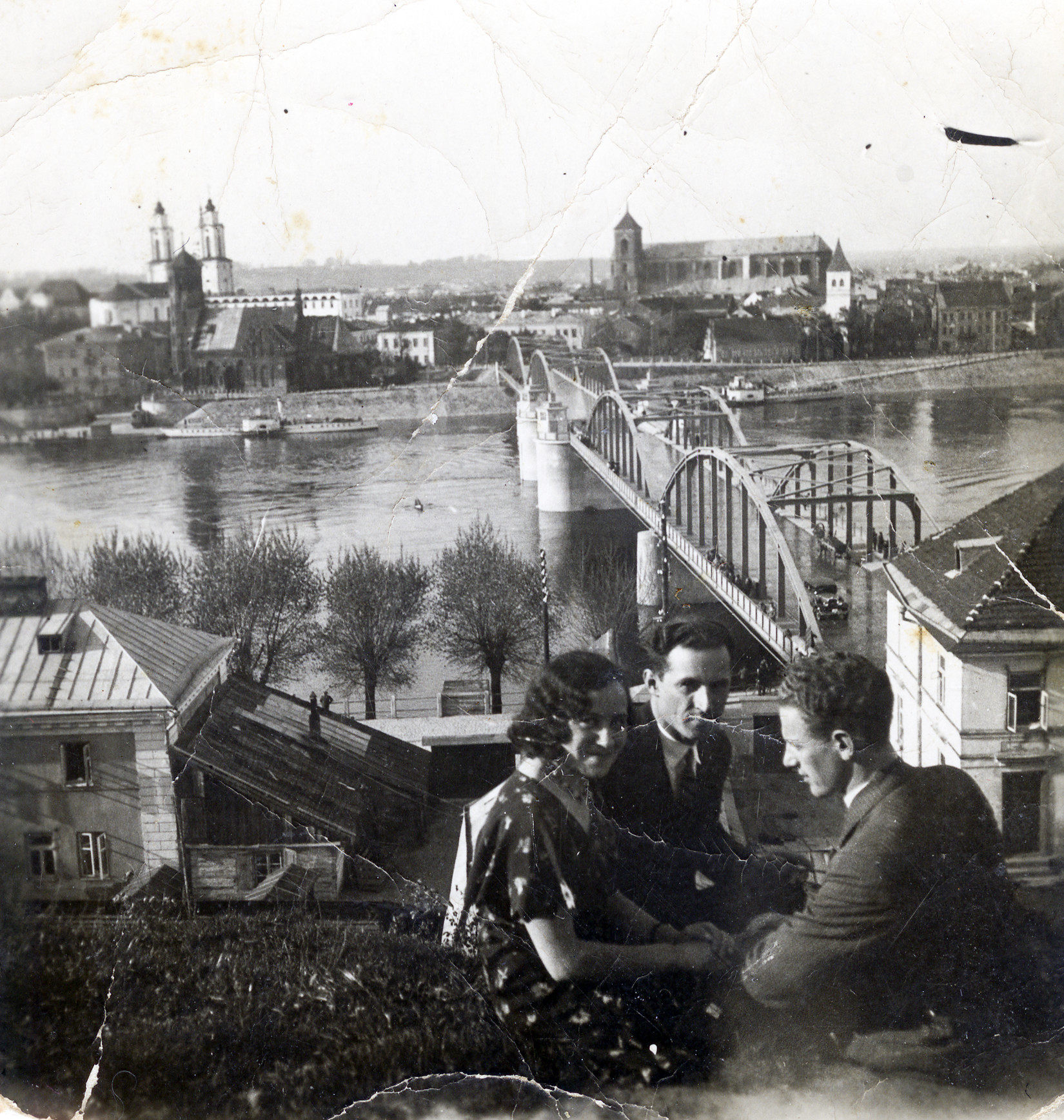 Lithuanian Jewish siblings seated together, overlooking a river in Kovno.

Pictured are Genia Kopelanski and her two brothers, Yaakov and Leib.