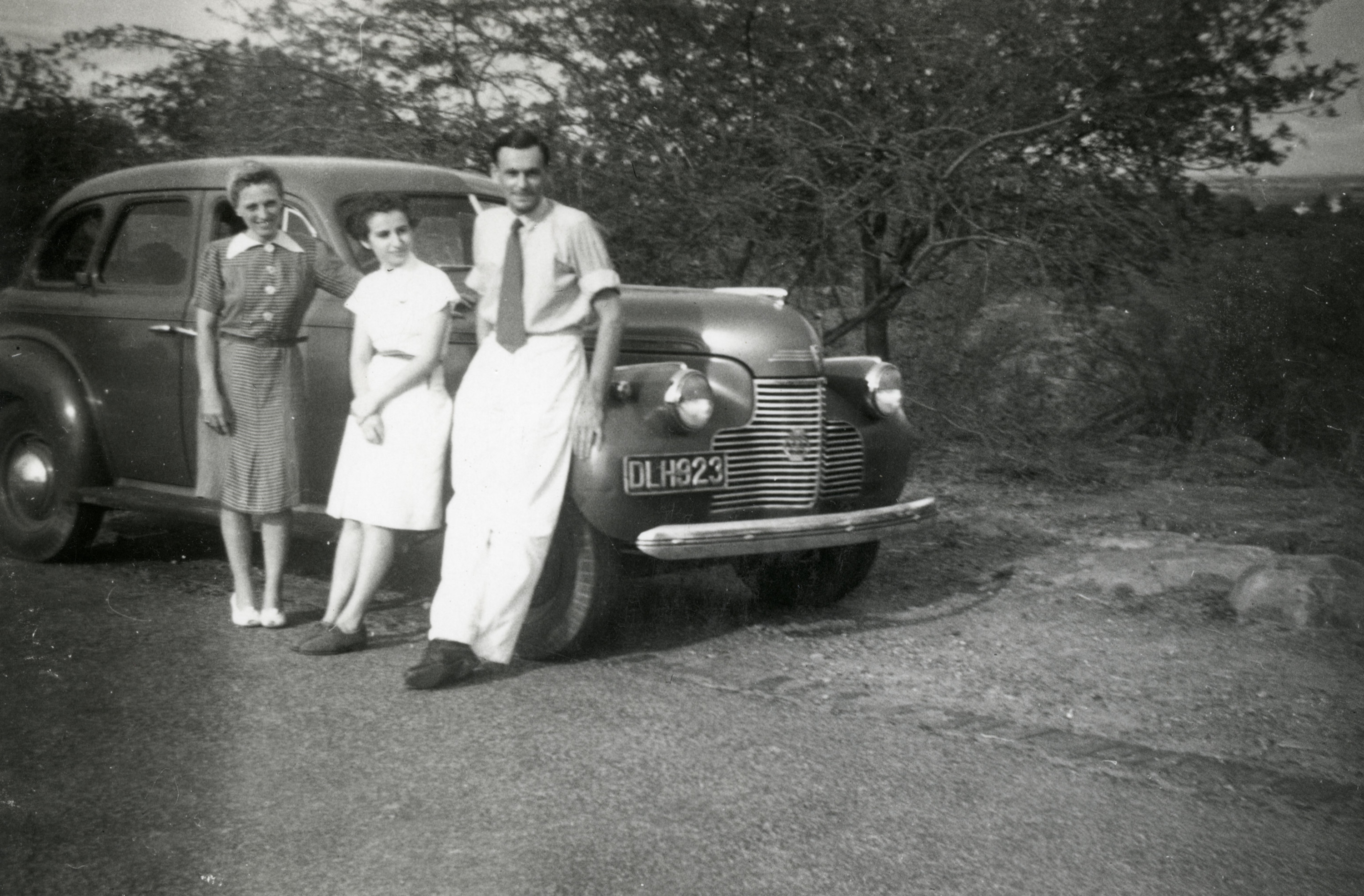 A Jewish teenager  poses with others next to a car, on her arrival to Bombay, India. 

Among those pictured is Valerie ("Vally") Herlinger (center).