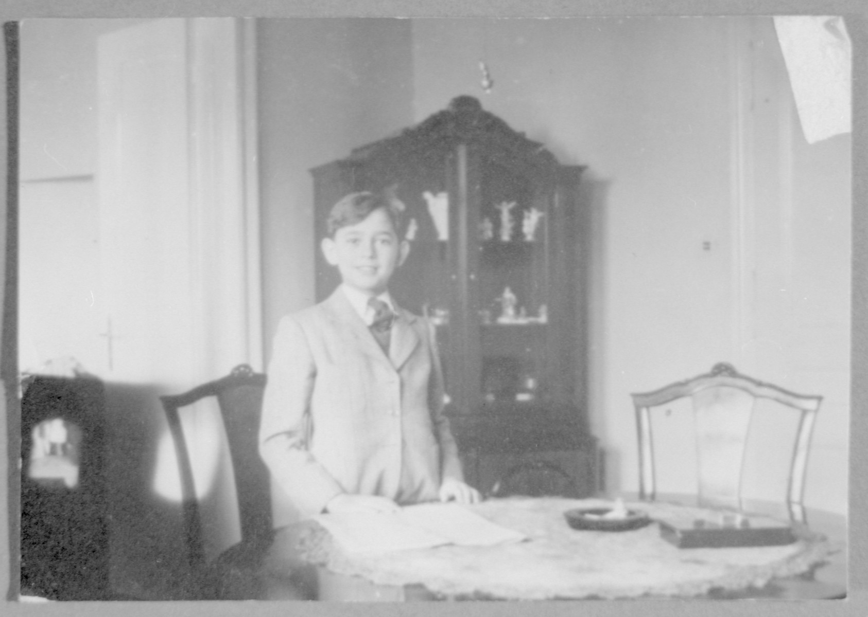 Roman Frister stands by the dining room table in his home.