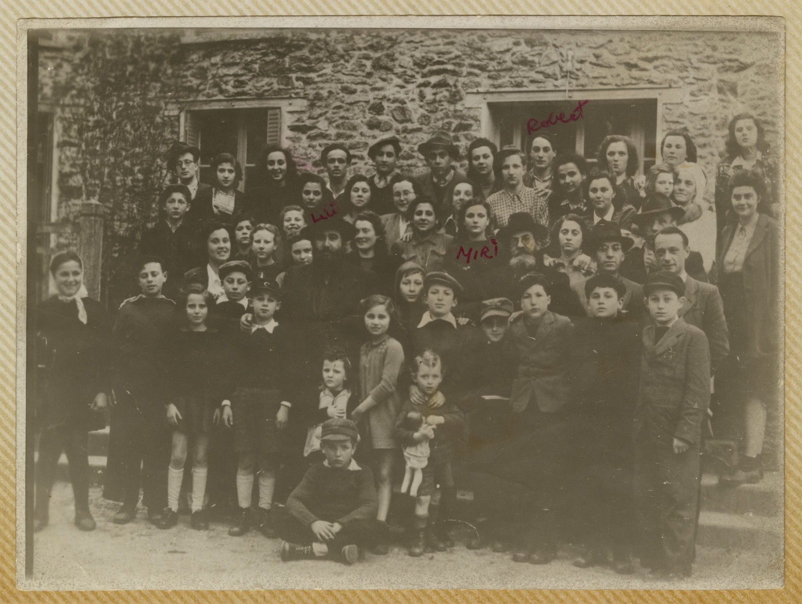 Group portrait of men, women and children in the Barbizon displaced persons camp in France.

Miriam Ofer is pictured in the center to the left of the rabbi.  Her brother Robert is standing on the top row, fourth from the right.
