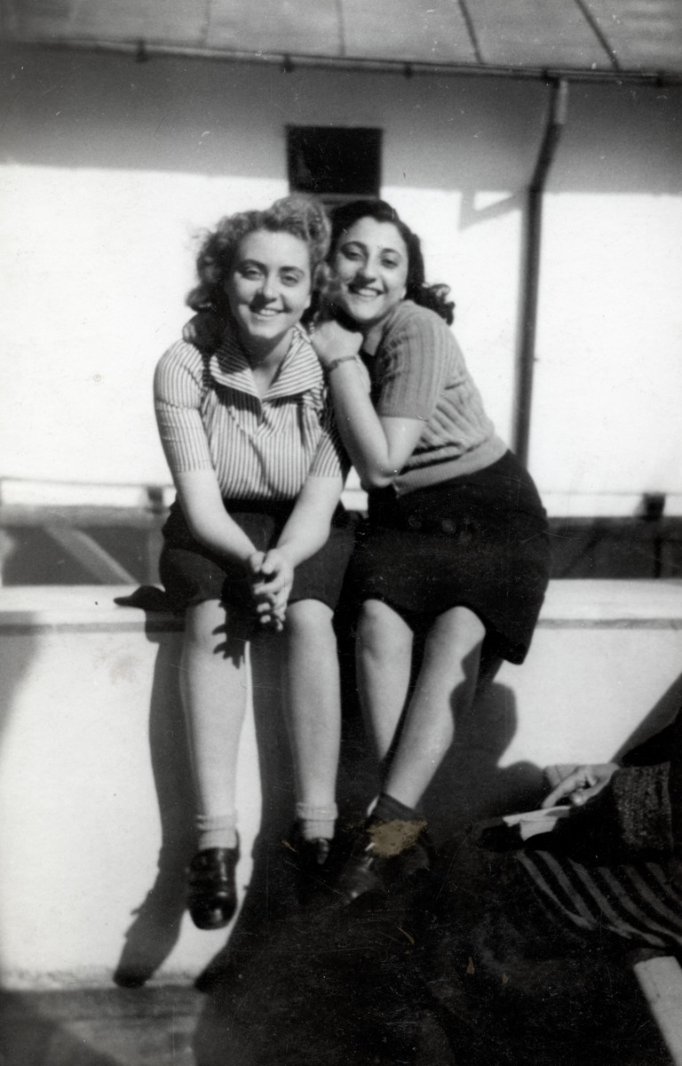 Two Jewish girls sit next to each other in the courtyard of the jail in ...