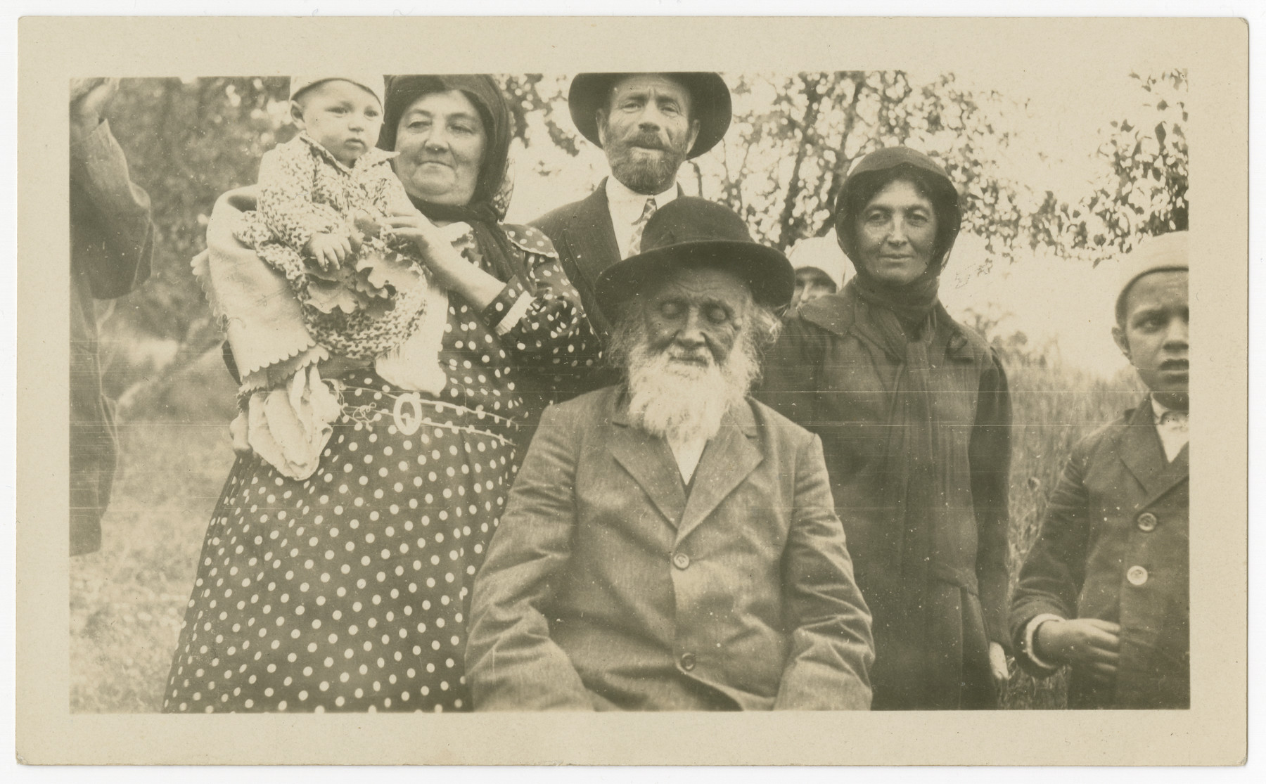 Members of the Hausman  family pose for a portrait outdoors.