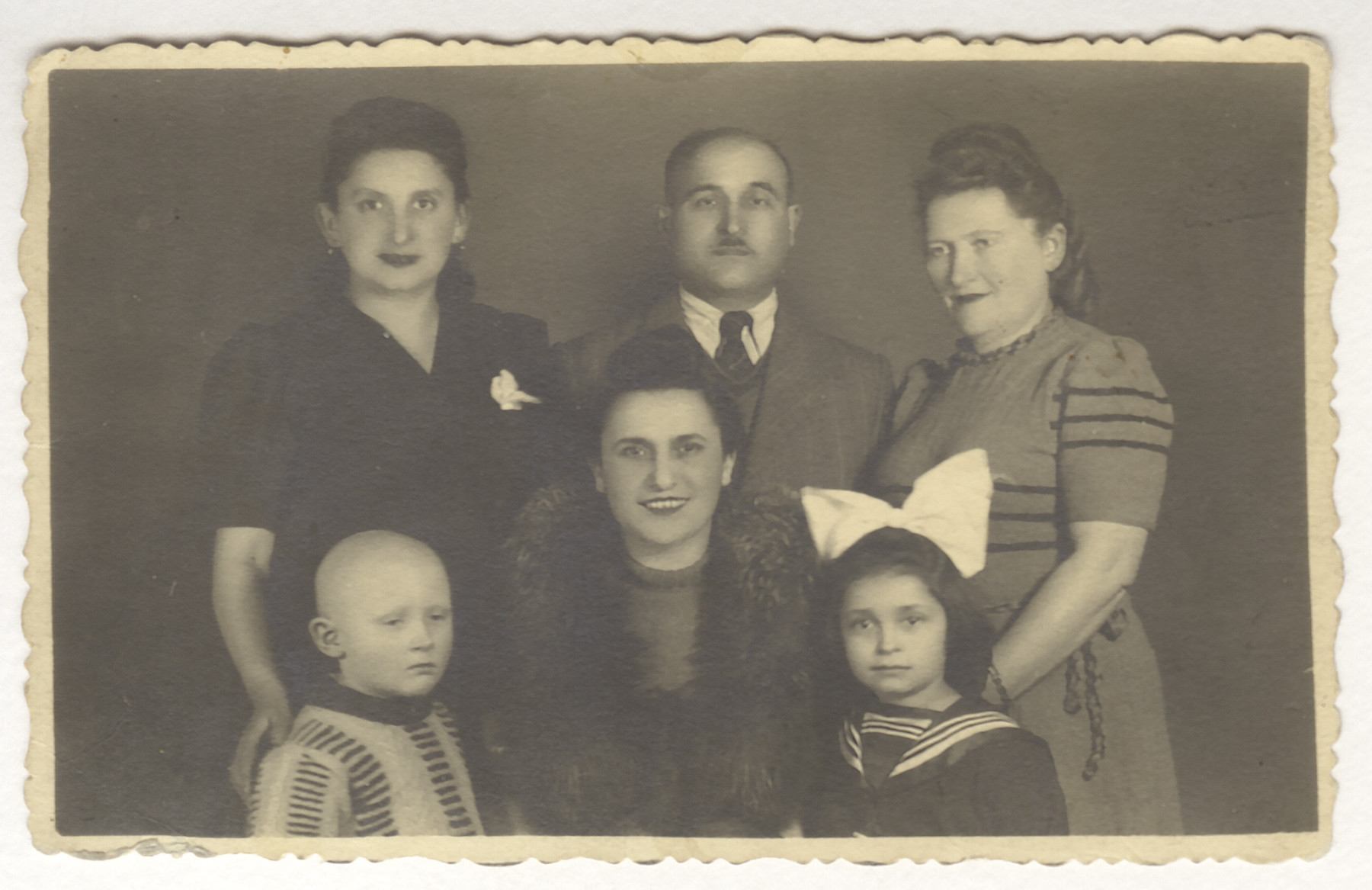 Studio portrait of surviving members of the Jonisch family.

Top row: Cecia Jonisch, Sam Jonisch, Sophie Jonisch Bornstein.  Bottom row: Michael Bornstein, Hilda Jonisch and Ruth Jonisch.