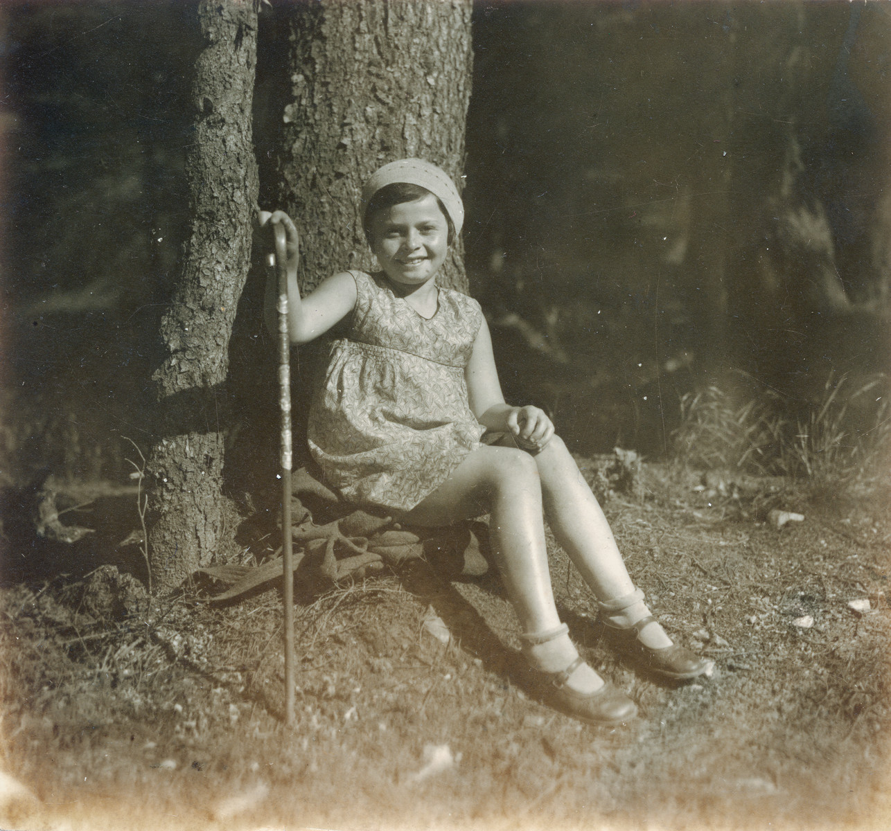 Hana Lustig rests under a large tree during a hike.