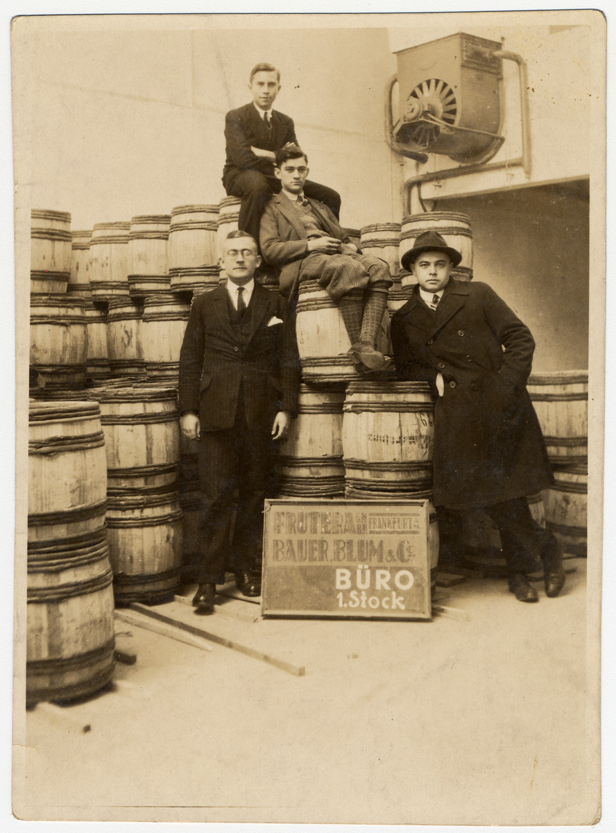 Four German-Jewish men pose next to wooden  barrels in the Bauer, Blum & Co. Frutera.