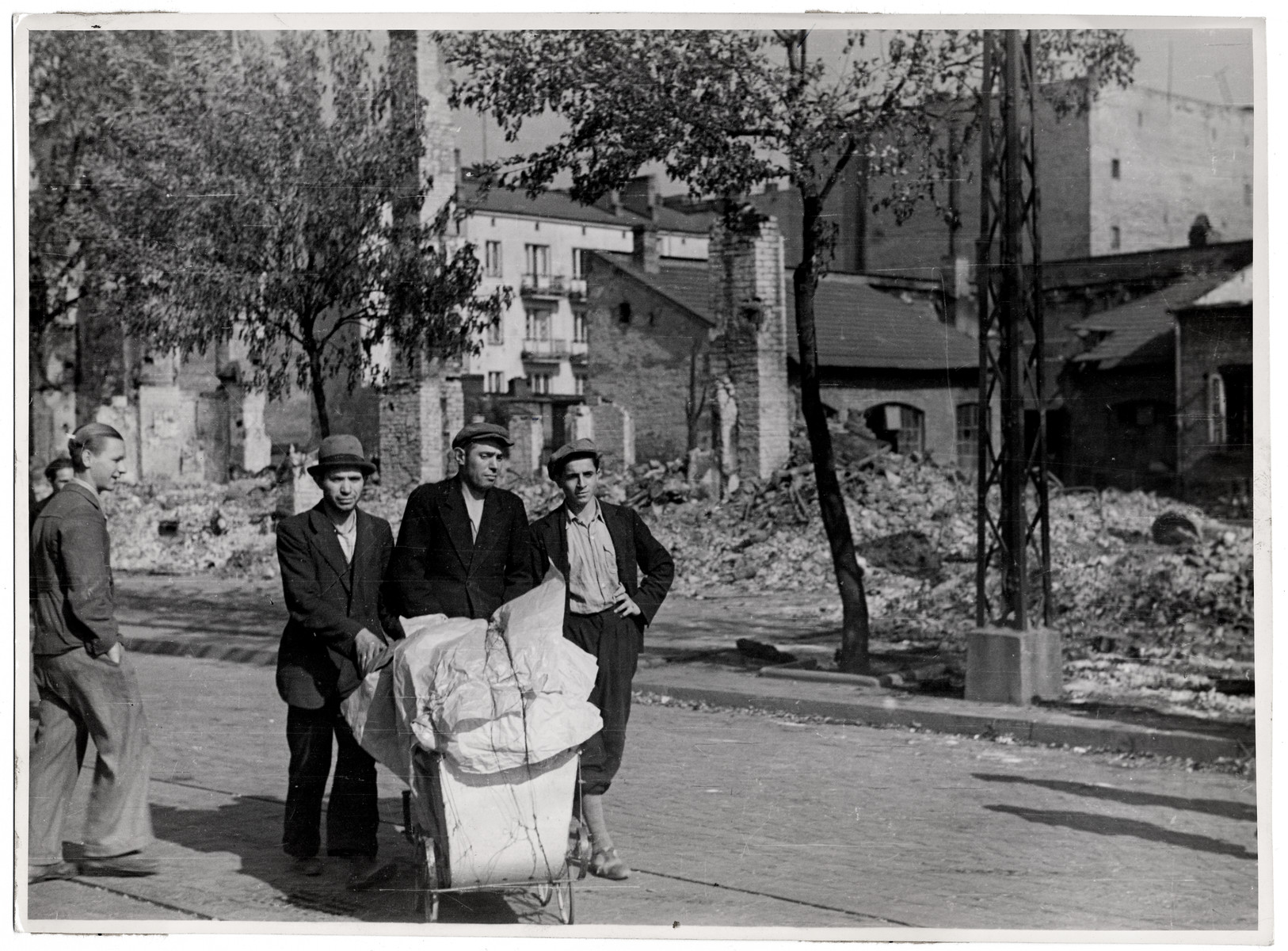 Polish men wheel a baby carraige full of supplies through the besieged city of Warsaw.