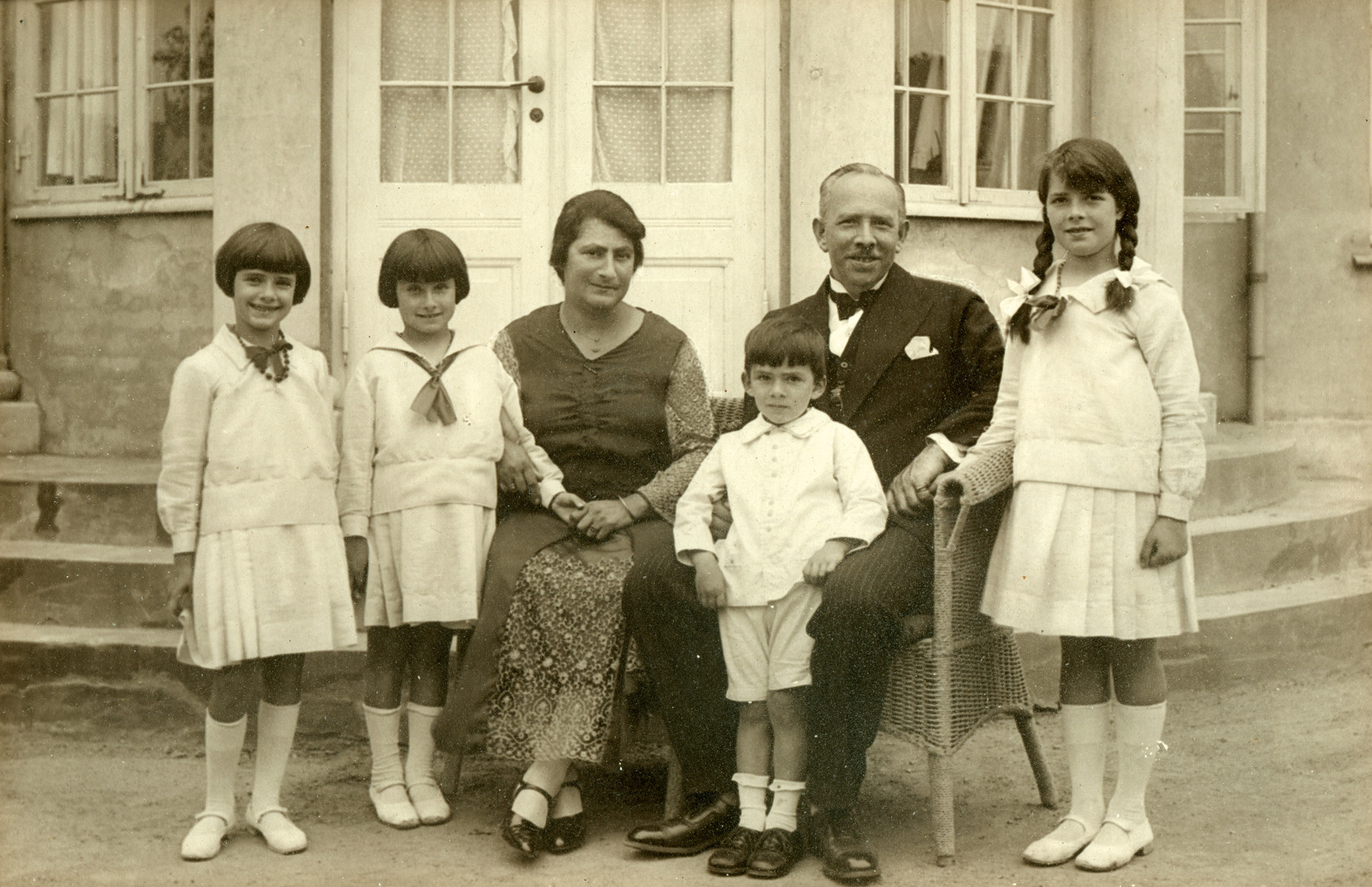 The Oestermann family celebrates Moritz Oestermann's fiftieth birthday in a mansion they rented for the occasion.

Pictured are Margot, Lillian, Gertrud, Richard, Moritz and Else Oestermann.