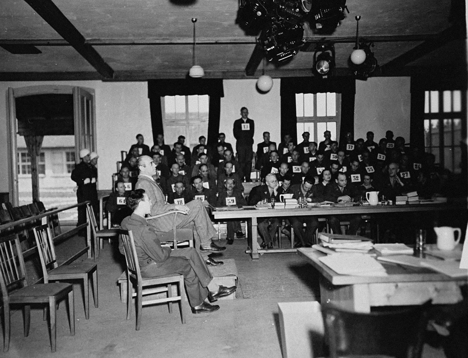 A witness testifies at the trial of 61 former camp personnel and prisoners from Mauthausen.  

Standing in the defendants' dock at back is August Eigruber, former Gauletier of Upper Austria.