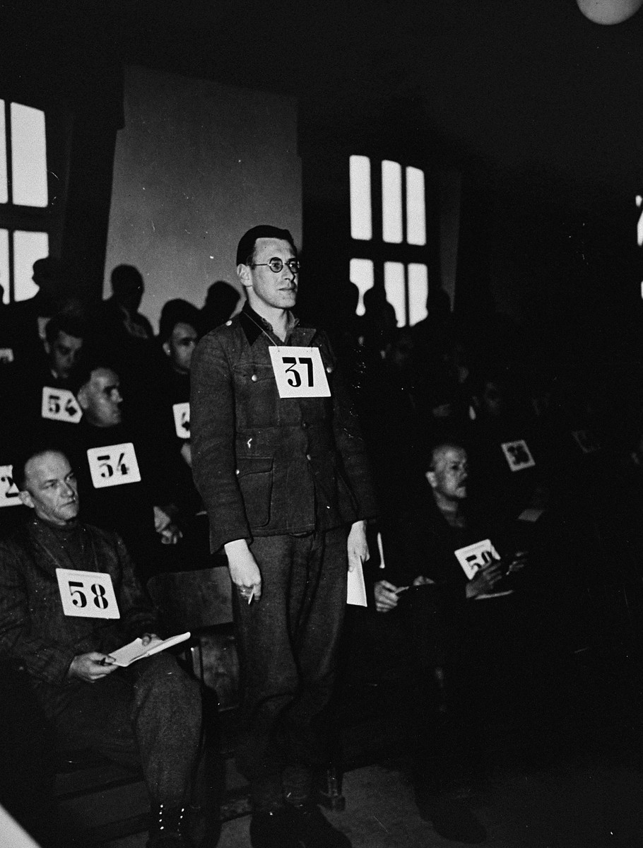 Former SS-Unterscharfuehrer Josef Leeb, a defendant at the trial of 61 former camp personnel and prisoners from Mauthausen, stands in his place in the defendants' dock.  

Leeb was convicted and sentenced to death on May 13, 1946.