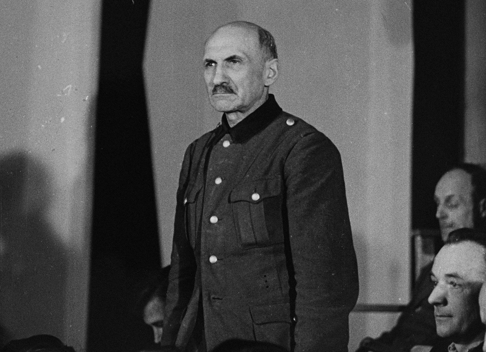 Werner Grahn, a defendant at the trial of 61 former camp personnel and prisoners from Mauthausen, stands in his place in the defendants' dock.