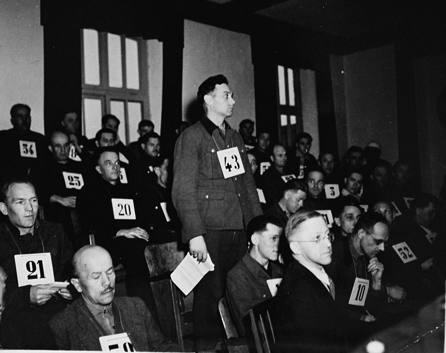 Former SS-Unterscharfuehrer Wilhelm Mueller, a defendant at the trial of 61 former camp personnel and prisoners from Mauthausen, stands in his place in the defendants' dock.  

Muellert was convicted and sentenced to death on May 13, 1946.