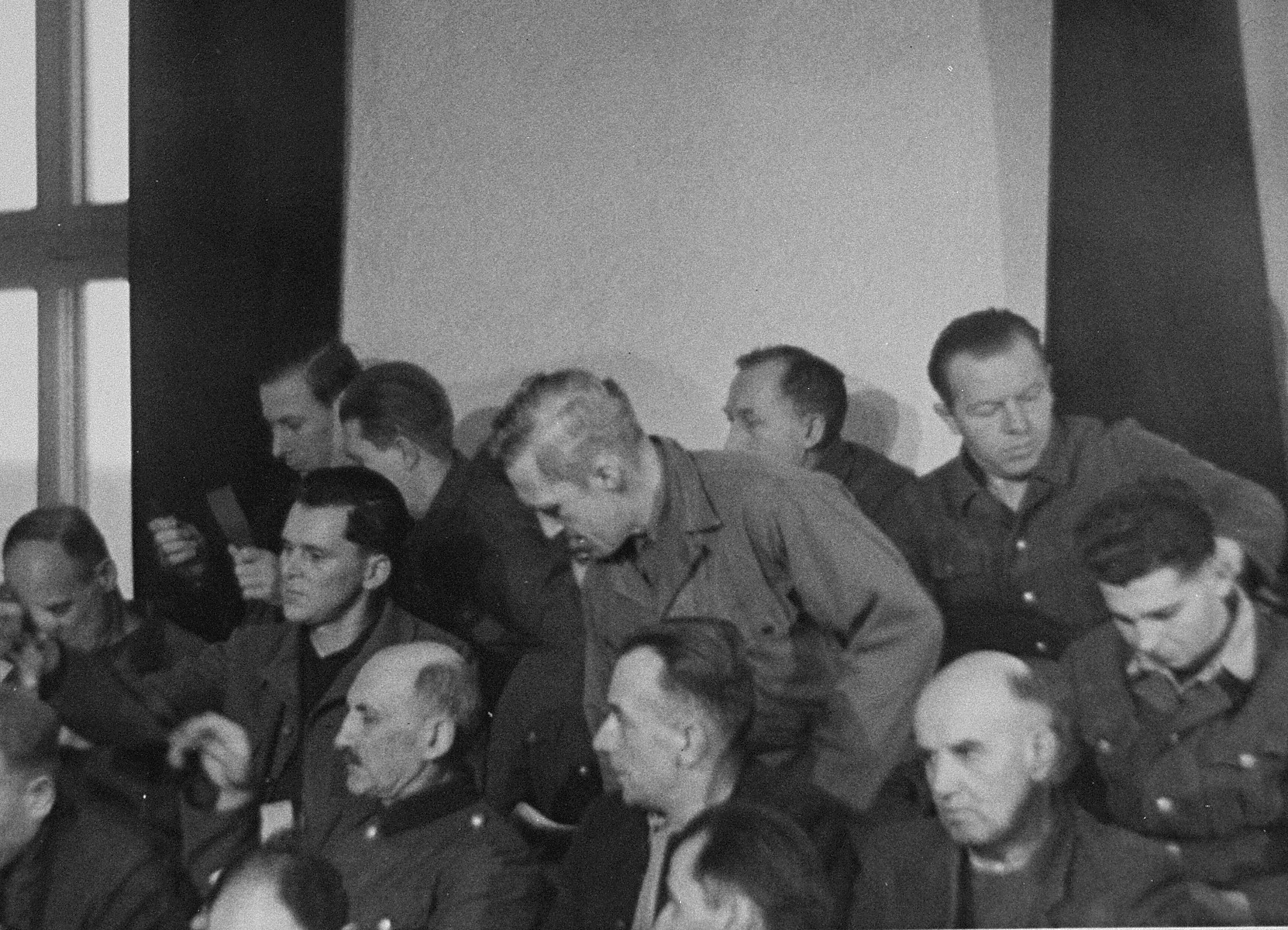 The defendants take their seats in the dock at the trial of 61 former camp personnel and prisoners from Mauthausen.  

Pictured in the middle is August Eigruber, former Gauleiter of Upper Austria.