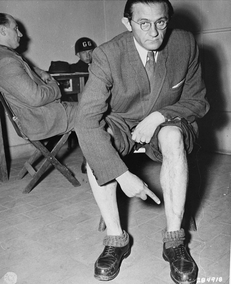 Joseph Spektor, a witness for the prosecution at the trial of former camp personnel and prisoners from Buchenwald, points to scars from maltreatment he received as a prisoner.