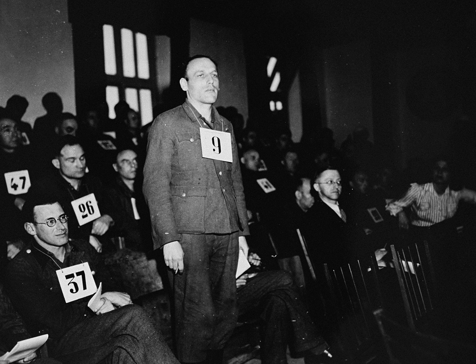 Former SS-Unterscharfuehrer Hans Diehl, a defendant at the trial of 61 former camp personnel and prisoners from Mauthausen, stands in his place in the defendants' dock.  

Diehl was convicted and sentenced to death on May 13, 1946.