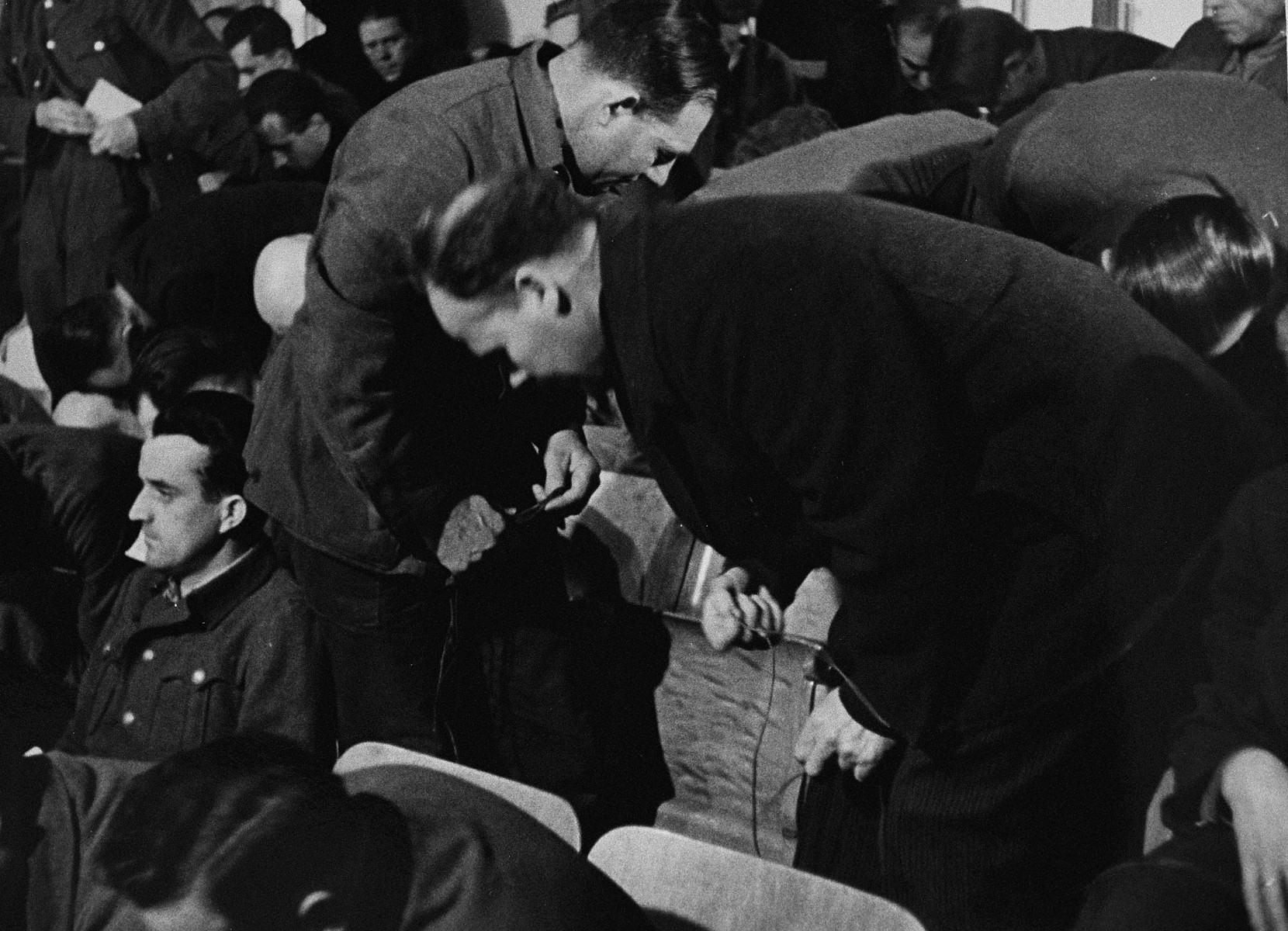 The defendants untangle cables in the dock at the trial of 61 former camp personnel and prisoners from Mauthausen.