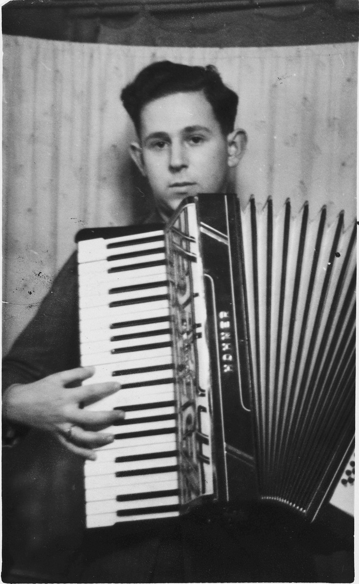 Portrait of Wilhelm Beigel playing an accordian in a displaced persons camp in Gailingen, Germany.
