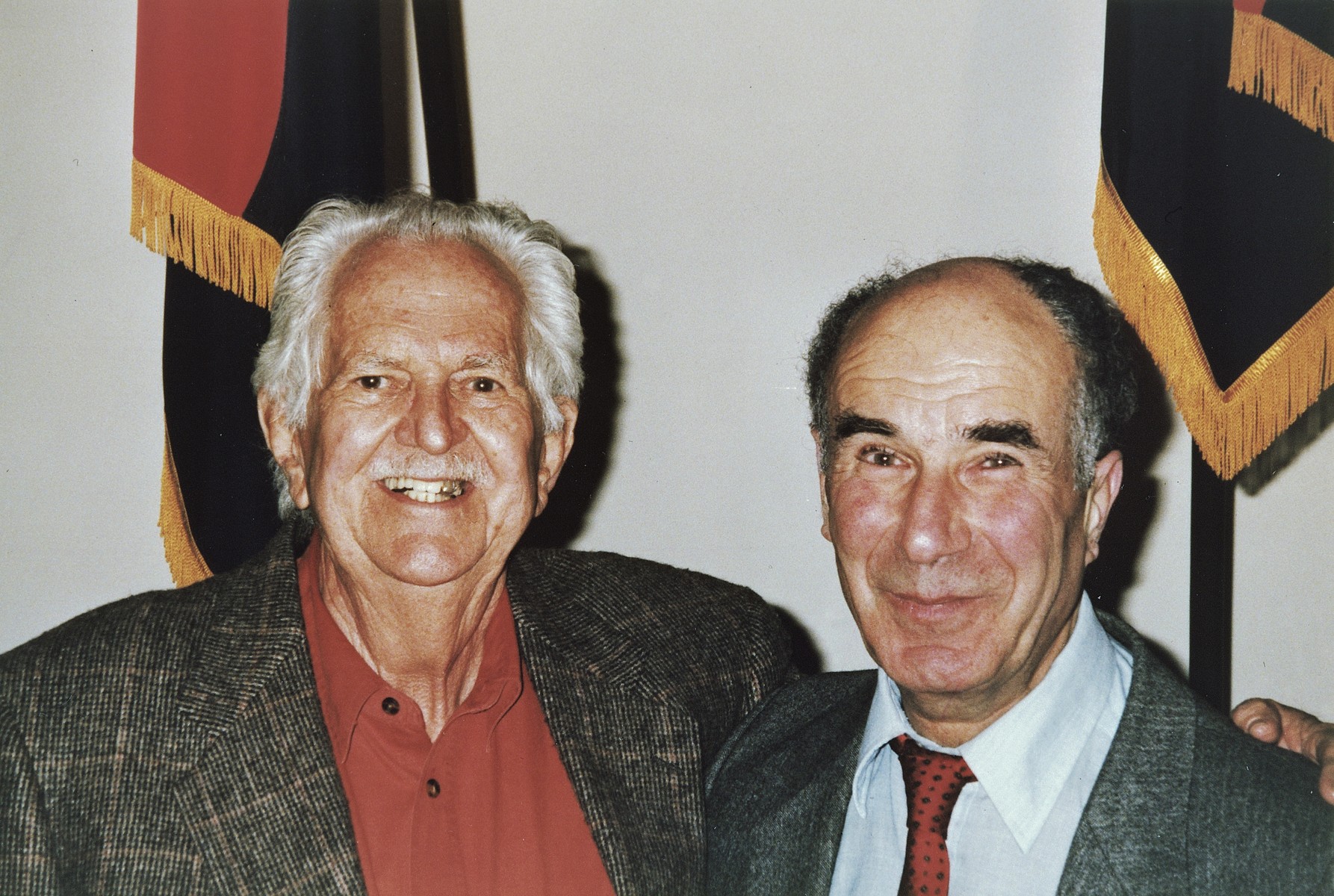 Portrait of American liberator Arnold E. Samuelson (left) and survivor George Havas (right) in front of the liberator flags at the U.S. Holocaust Memorial museum.