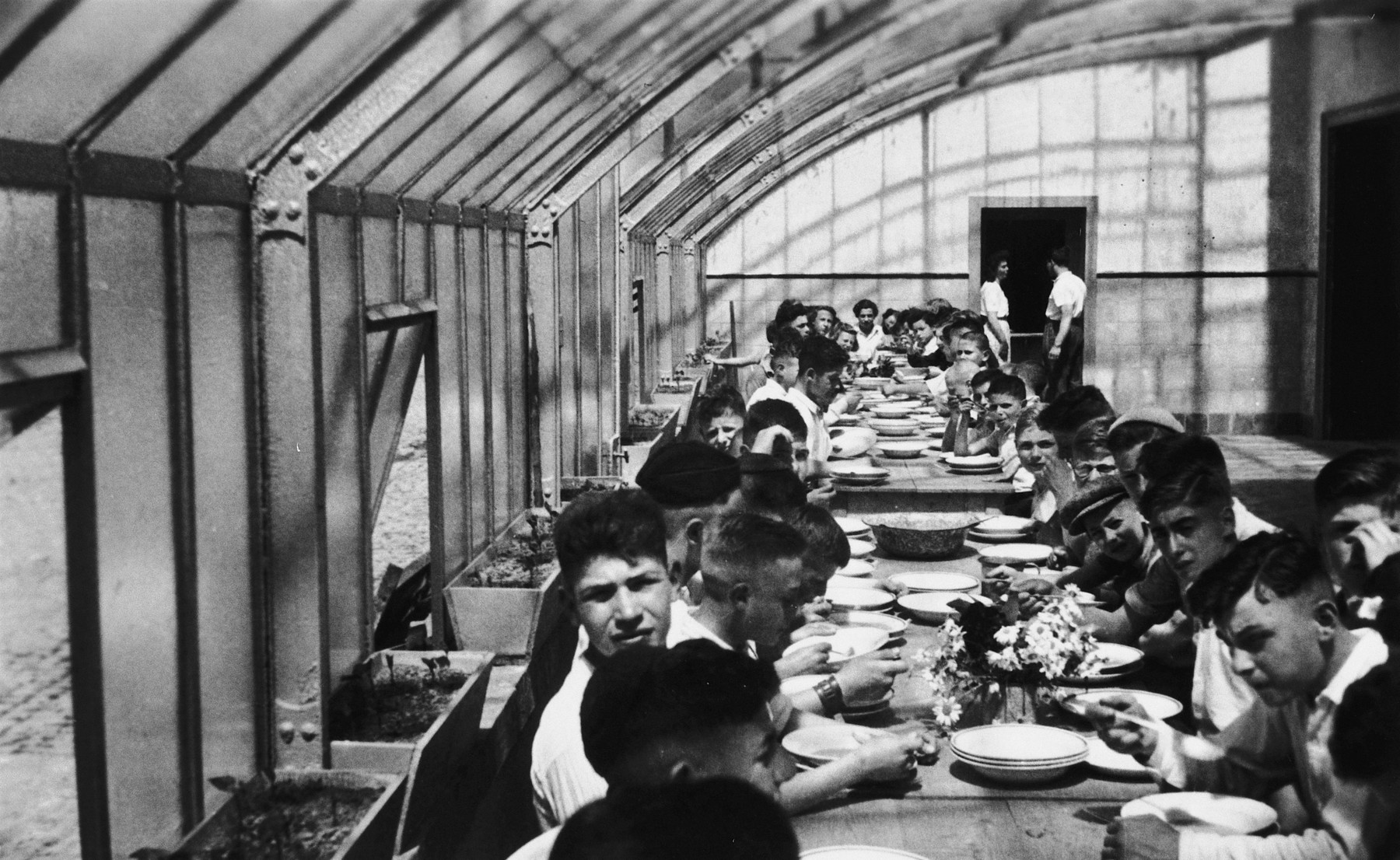 Jewish children eat a meal in the dining room of the children's home in Aische-en-Refail.

Hirsch Grunstein is fourth from the right in a cap.