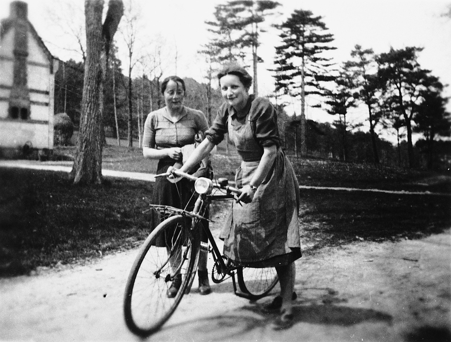 Magrit Taennler rides a bicycle near Chateau de la Hille while Ms. Tobler looks on.