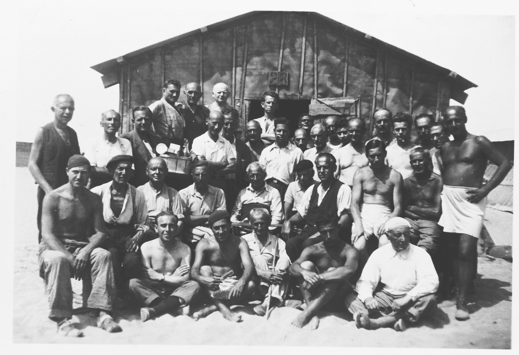 Group portrait of prisoners in front of a barracks in the Gurs transit camp.