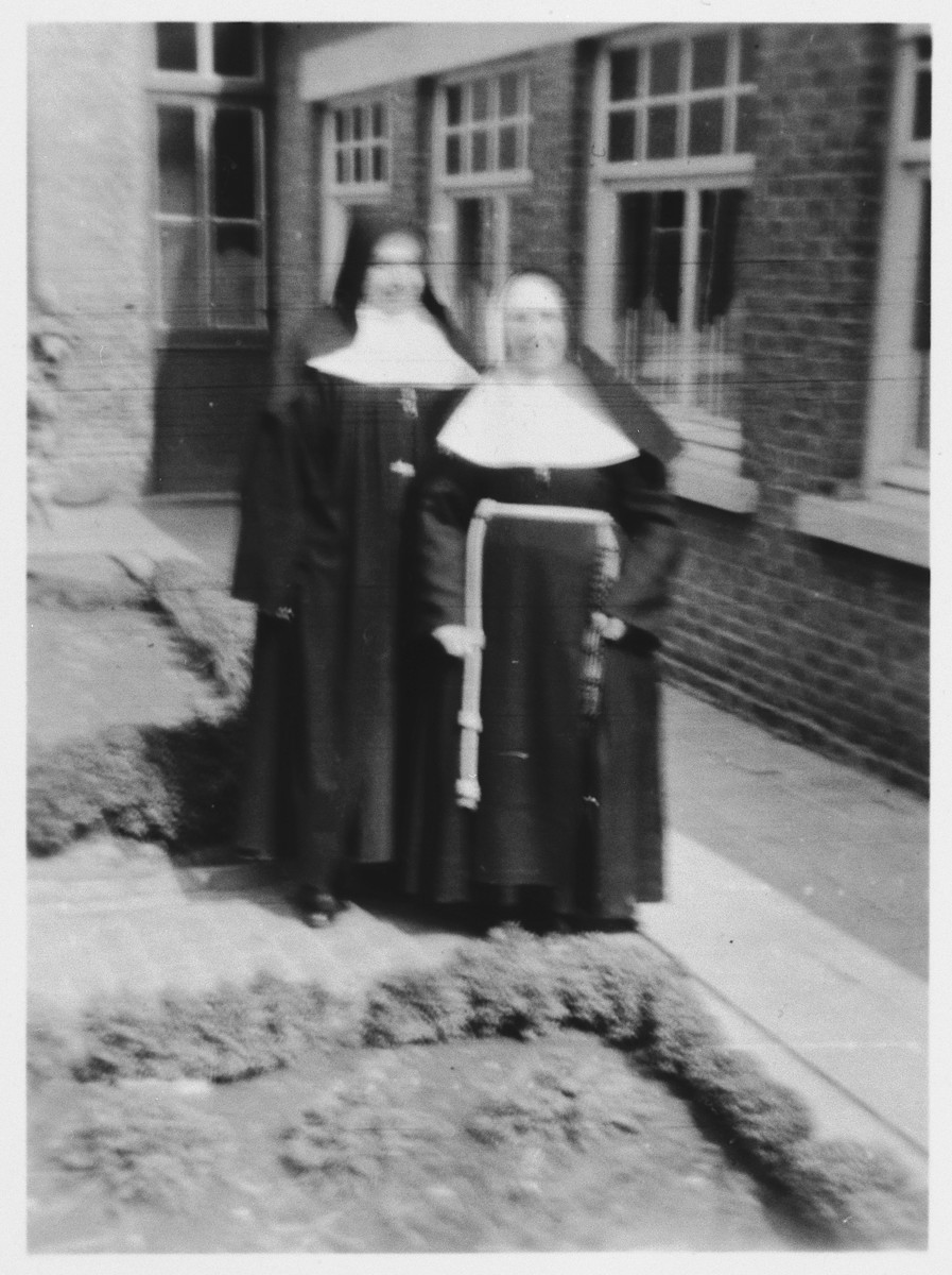 Two nuns pose outside the convent in Doel, Belgium, where Jewish children were hidden during the German occupation.

One of the nuns is Sister Ordonia, who hid the three Mendelowicz sisters for three months.