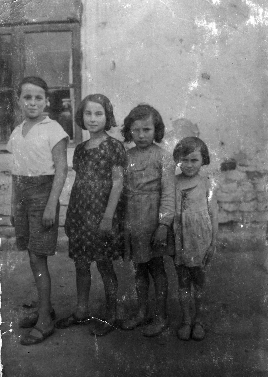 Four Jewish siblings pose outside their home in Sosnowiec, Poland.

Pictured from left to right are: Tzvi, Genia, Frania and Sala Dunski.