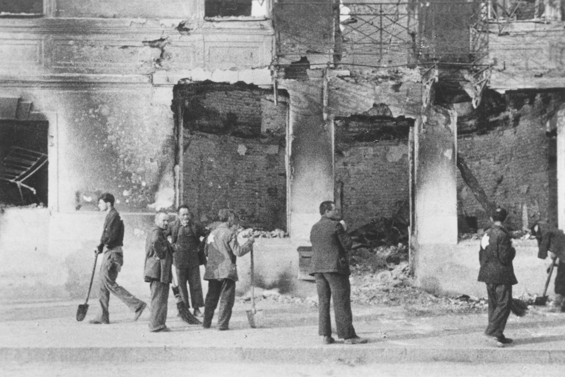 Jews at forced labor clearing rubble from a bombed out building.

The photograph was probably taken by a member of Police Battalion 101. 

One image from a photograph album belonging to a member of Police Battalion 101.