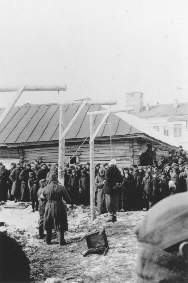 Local residents watch as the Germans publicly hang a woman on a gallows erected in the town square.

The photograph was probably taken by a member of Police Battalion 101. 

One image from a photograph album belonging to a member of Police Battalion 101.