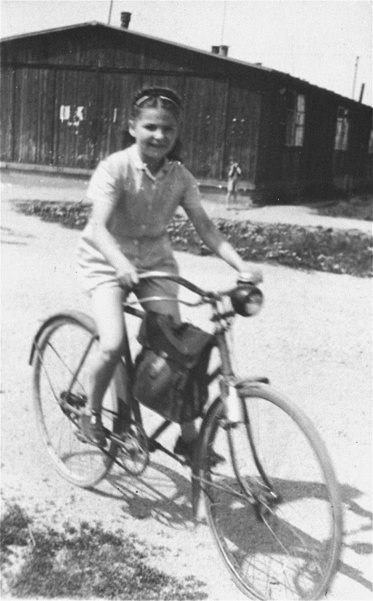 Frima Gleiser rides a bicycle in the Pocking (Schlupfing) displaced persons camp.