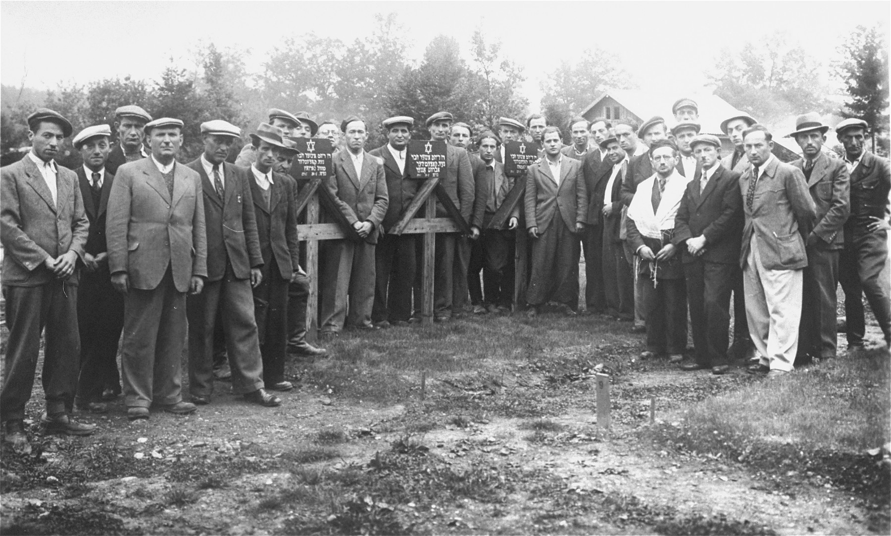 Jewish DPs gather for a memorial service in the Traunstein displaced persons camp.

Those pictured include Yankel Yakubovitz (the tall man in the center) and his brother, Aaron Yakubovitz. Pictured in the center, looking over the left shoulder of Yankel Yakubovitz is Chaim Cichowicz (later Herman Cane).