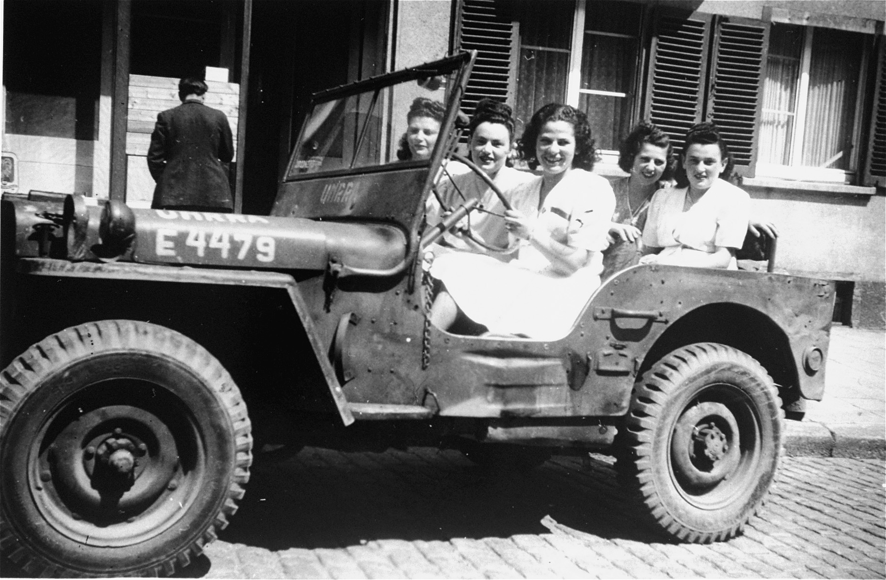 UNRRA nurses sit in a jeep outside the Stuttgart displaced persons camp.