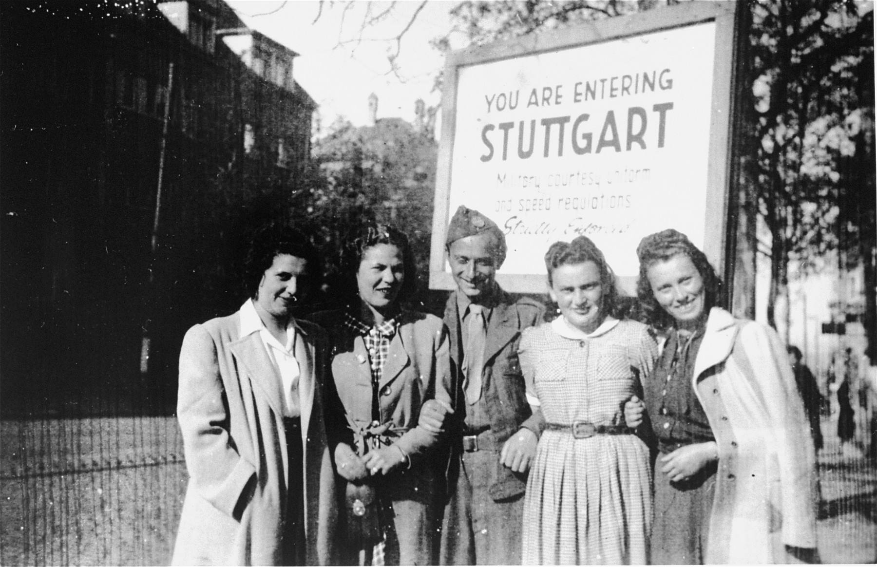 Henry Brauner with his wife, Esther (second from the right), and three friends at the entrance to the Stuttgart displaced persons camp.