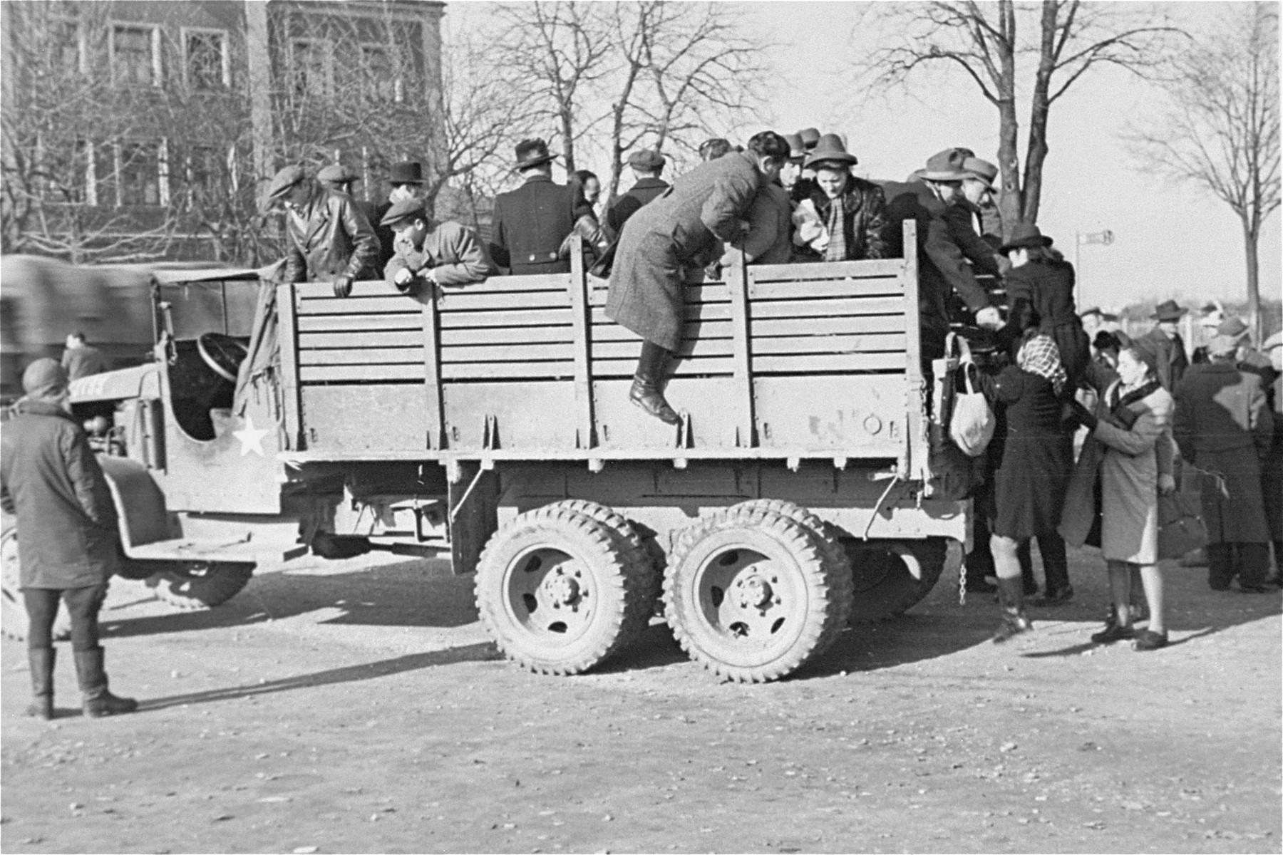 Departing Jewish DPs climb onto the back of a truck at a displaced persons camp in Germany.