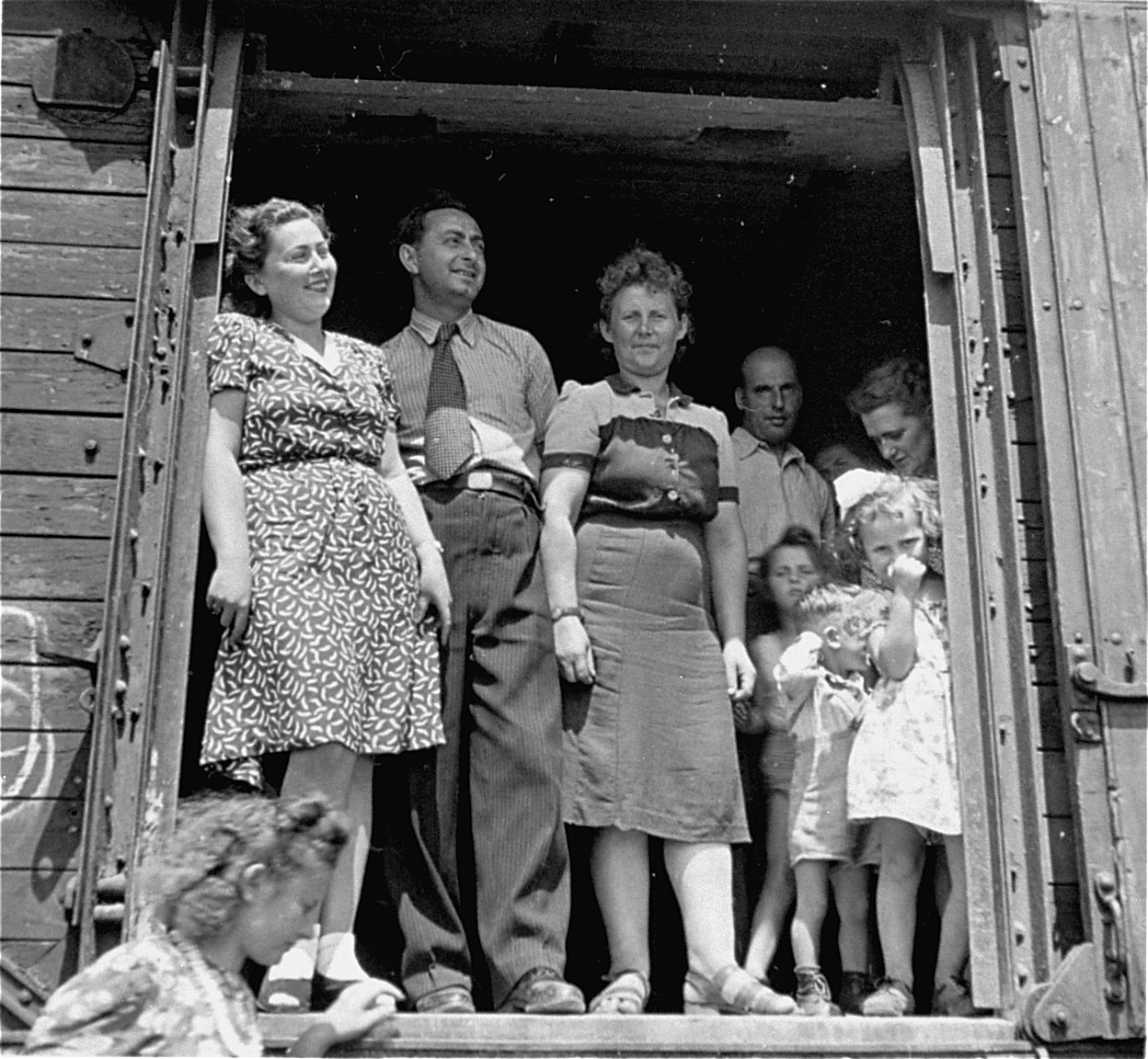 Departing Jewish DPs stand in the open door of a railcar.