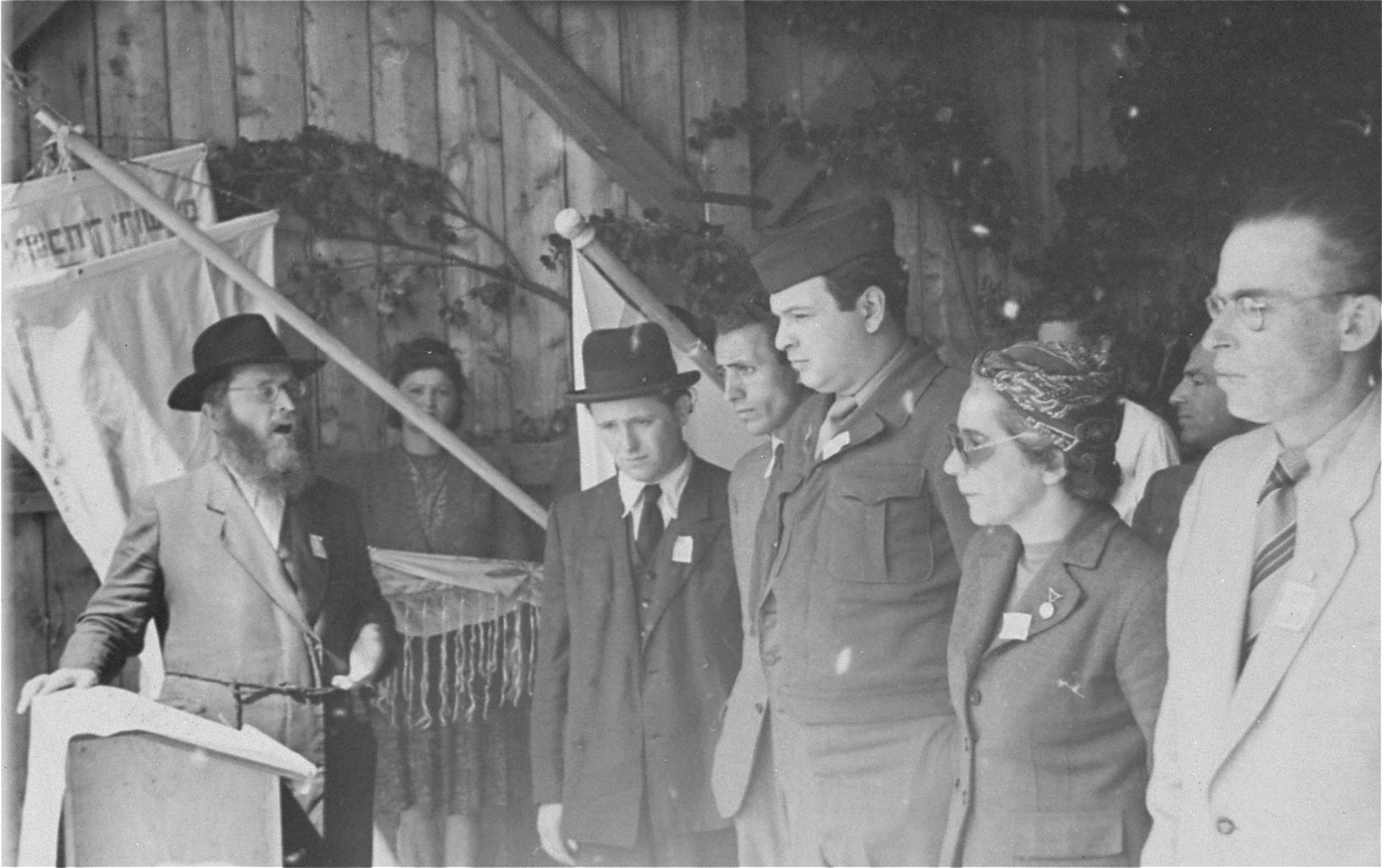 Director Saul Sorrin and other DP camp leaders listen as a cantor sings a hymn at a ceremony in the Neu Freimann displaced persons camp.