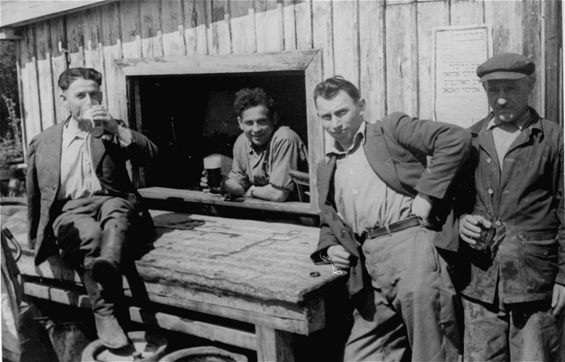 Jewish DPs drinking beer outside a canteen in the Neu Freimann displaced persons camp.
