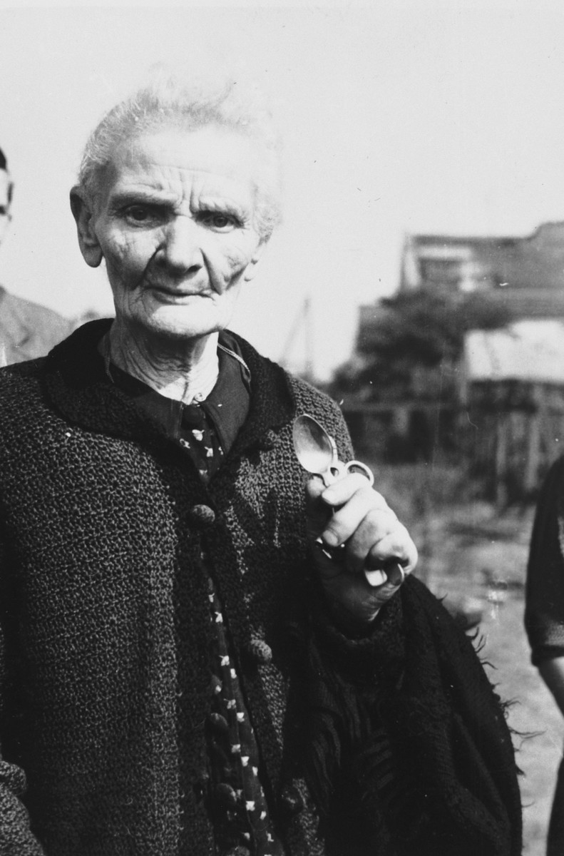 An elderly Polish woman poses with two silver spoons and a pair of scissors, all that remained of her home after it was destroyed in a German air raid during the siege of Warsaw.

The woman's name is Mrs. Jaworska.  Julien Bryan later learned that she died in 1940.