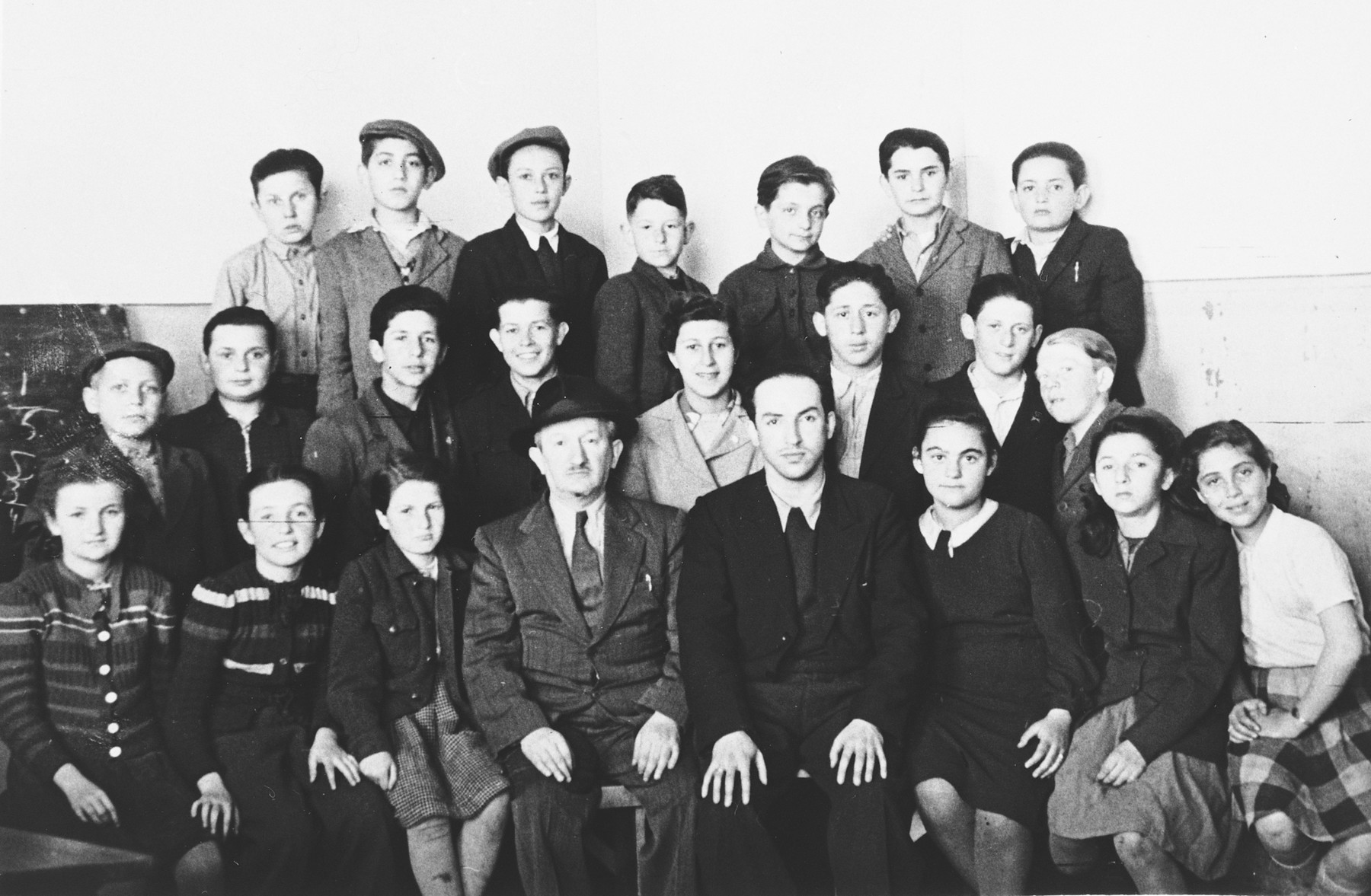 Group portrait of Jewish students and teachers in the Hasenecke DP camp school.

Pictured in the front row on the far right in the white shirt is Mania Wurm.