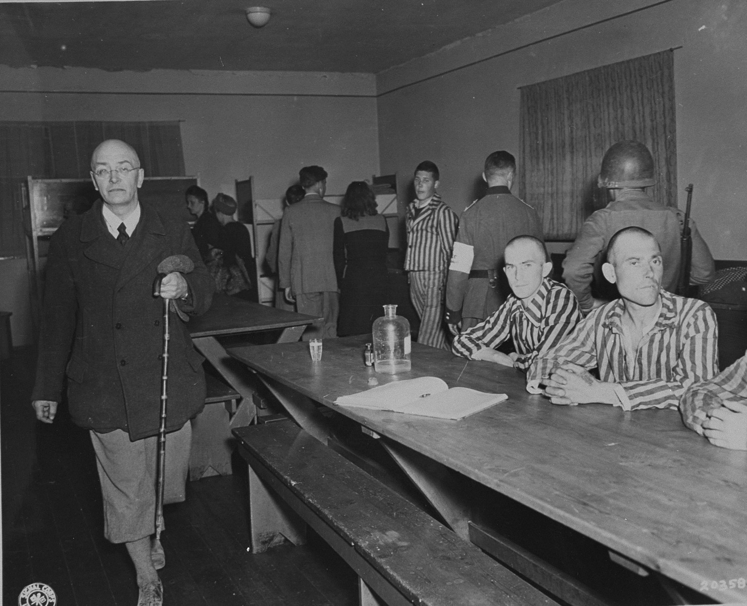 German civilians from Weimar under American military guard are forced to see the starved victims of Nazi brutality in Buchenwald.