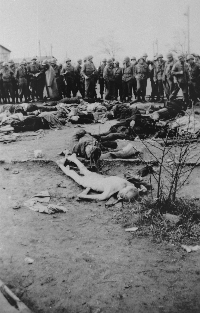 American soldiers view the bodies of prisoners shot by the SS during the liberation of the camp.